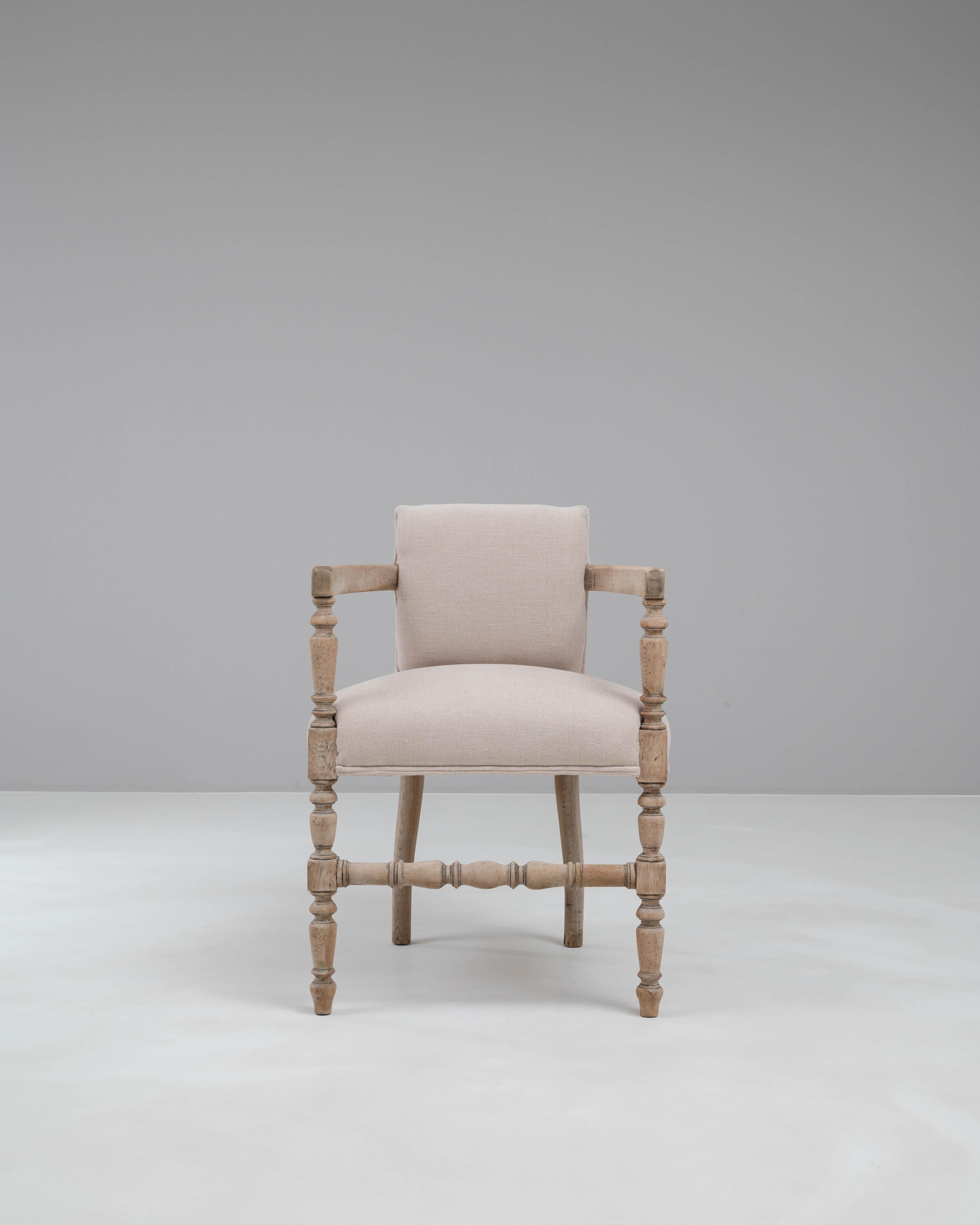 Elevate your space with the timeless elegance of this 20th Century French Bleached Oak Armchair. Crafted with meticulous attention to detail, this chair features a sturdy bleached oak frame with beautifully turned spindles and legs that exude a