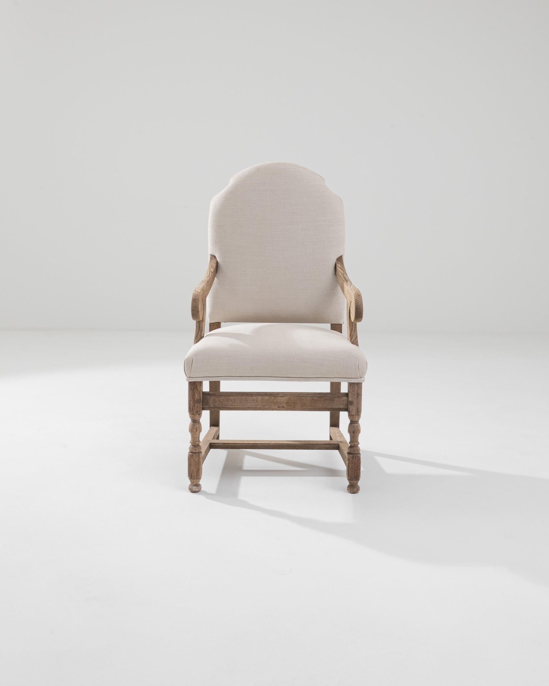 Thoughtfully reupholstered pair of bleach oak armchairs from 20th century France. Crafted from solid oak and expertly bleached to a soft, luminous patina, these armchairs bear the hallmark of French craftsmanship. The gentle curves and carved