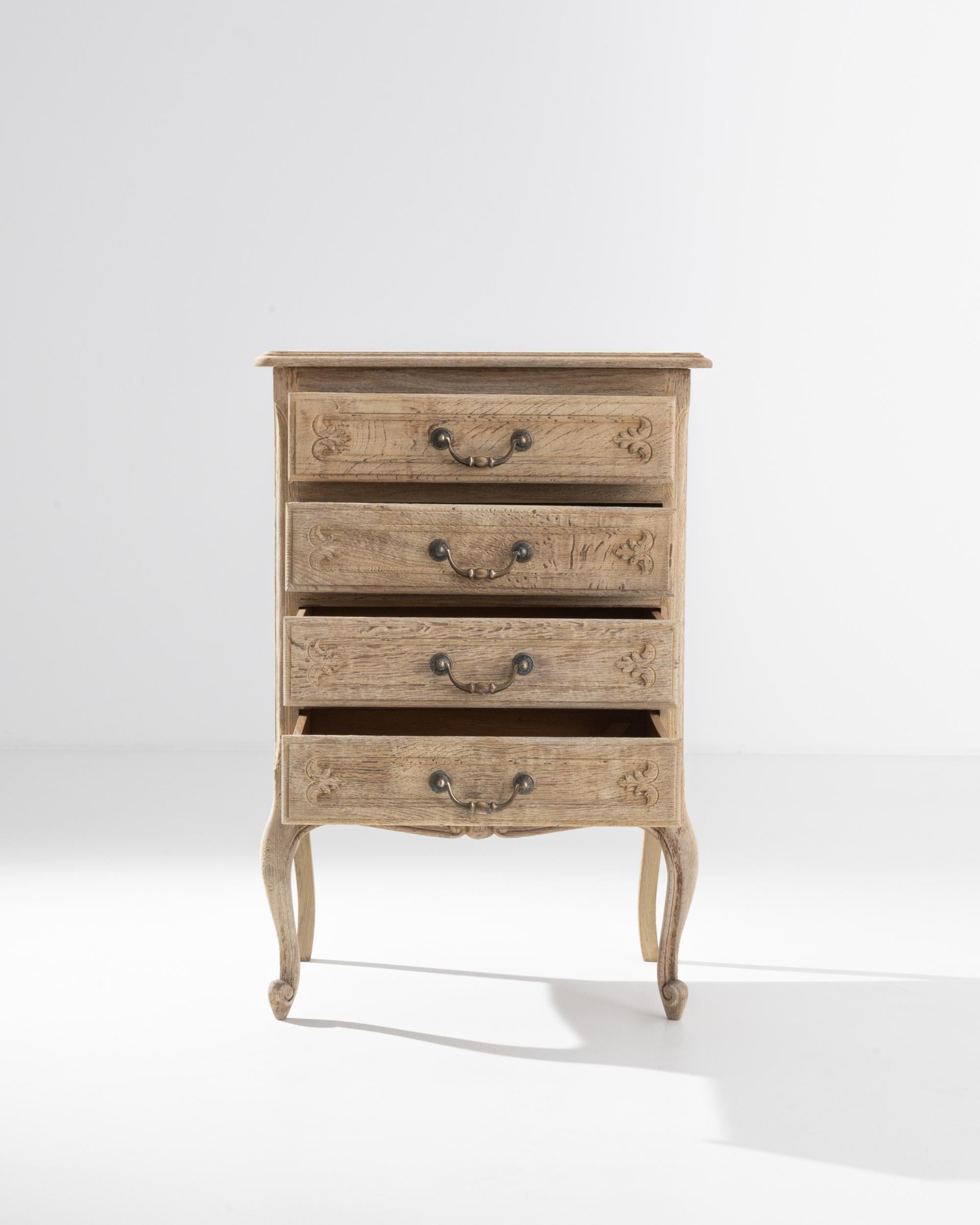 This elegant four-drawer chest features hand-crafted ornate details and graceful cabriole legs that show the true craftsmanship that went into creating this piece. Created in France during the 20th century, this dresser was handcrafted from oak that