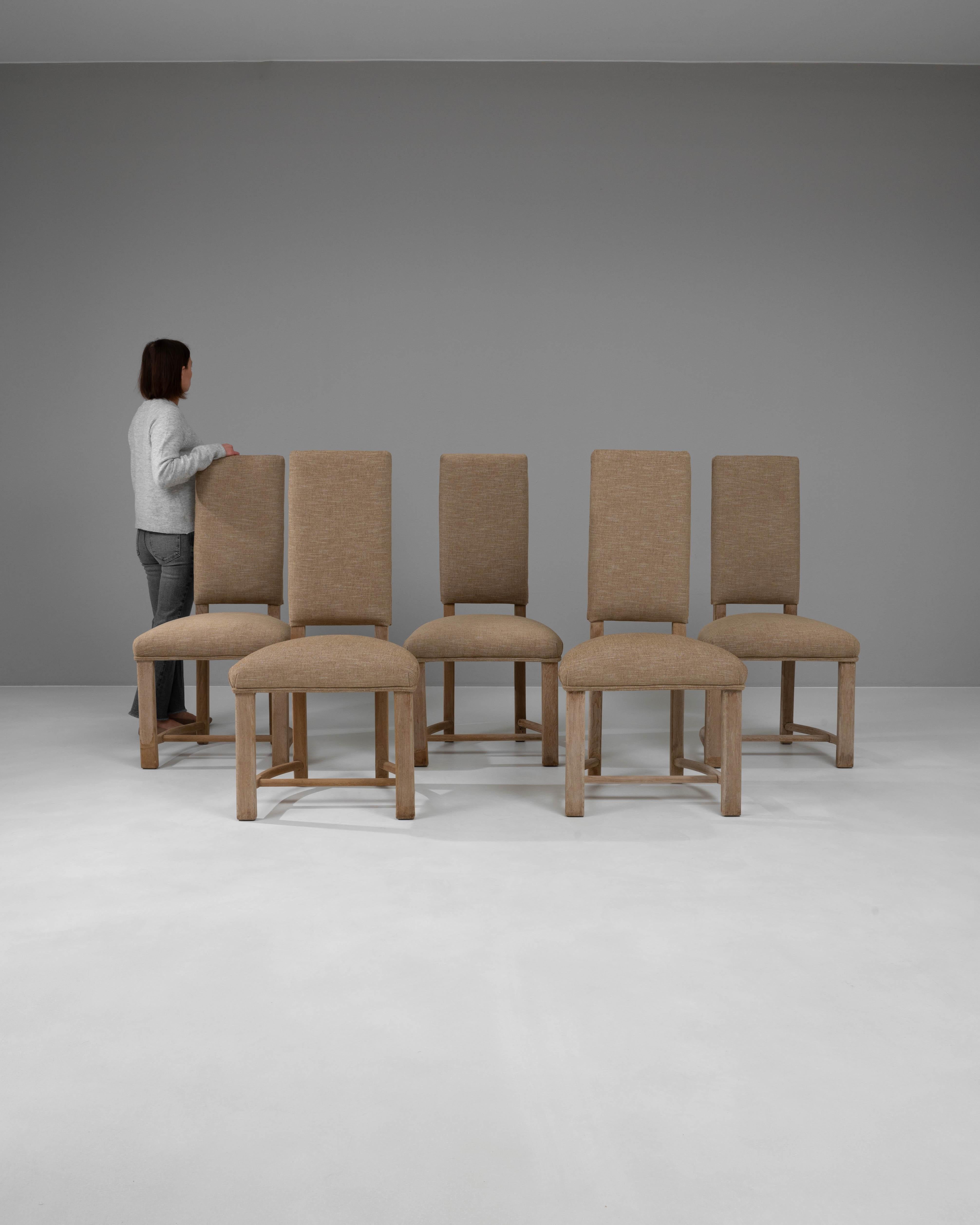 Wir präsentieren ein schickes und stromlinienförmiges Set von fünf Esszimmerstühlen aus gebleichter französischer Eiche des 20. Jahrhunderts, von denen jeder ein elegantes und minimalistisches Design aufweist, das jeden modernen Essbereich ergänzt.