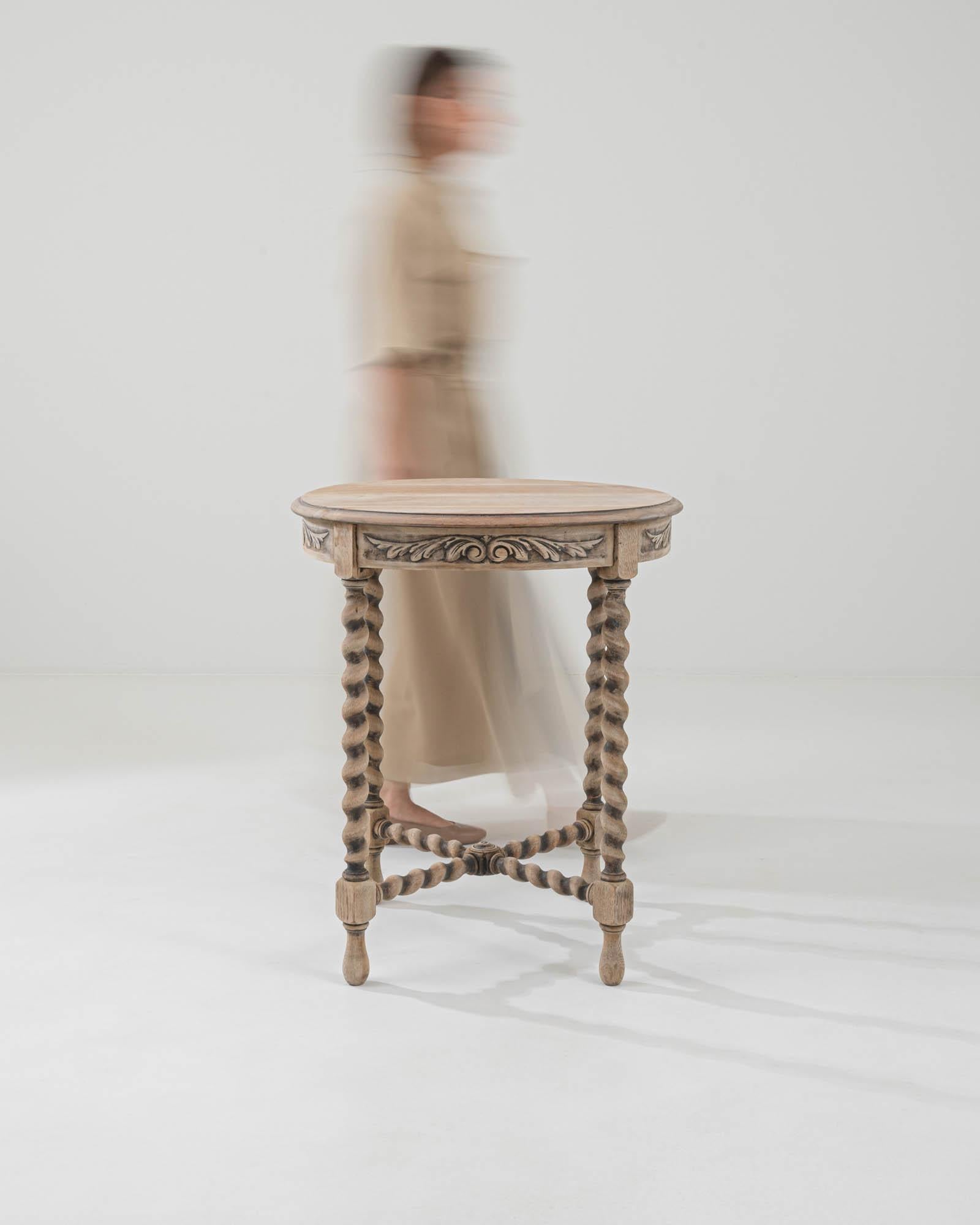 Elevate your living space with the understated beauty of this 20th Century French Bleached Oak Side Table. Originating from France, this oak side table boasts a circular top, providing a versatile surface for various uses. The simplicity of its