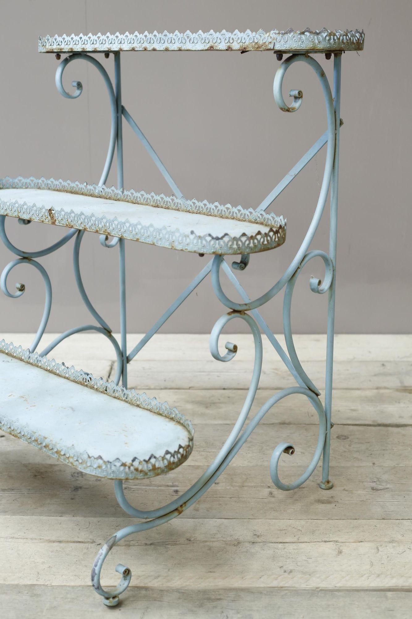 This is a 20th century blue painted French plant stand. 3 tiers with pierced boarders around each level which are great details. Overall condition is very good with an aged patina throughout. The scroll work detail to the frame gives it an elegant