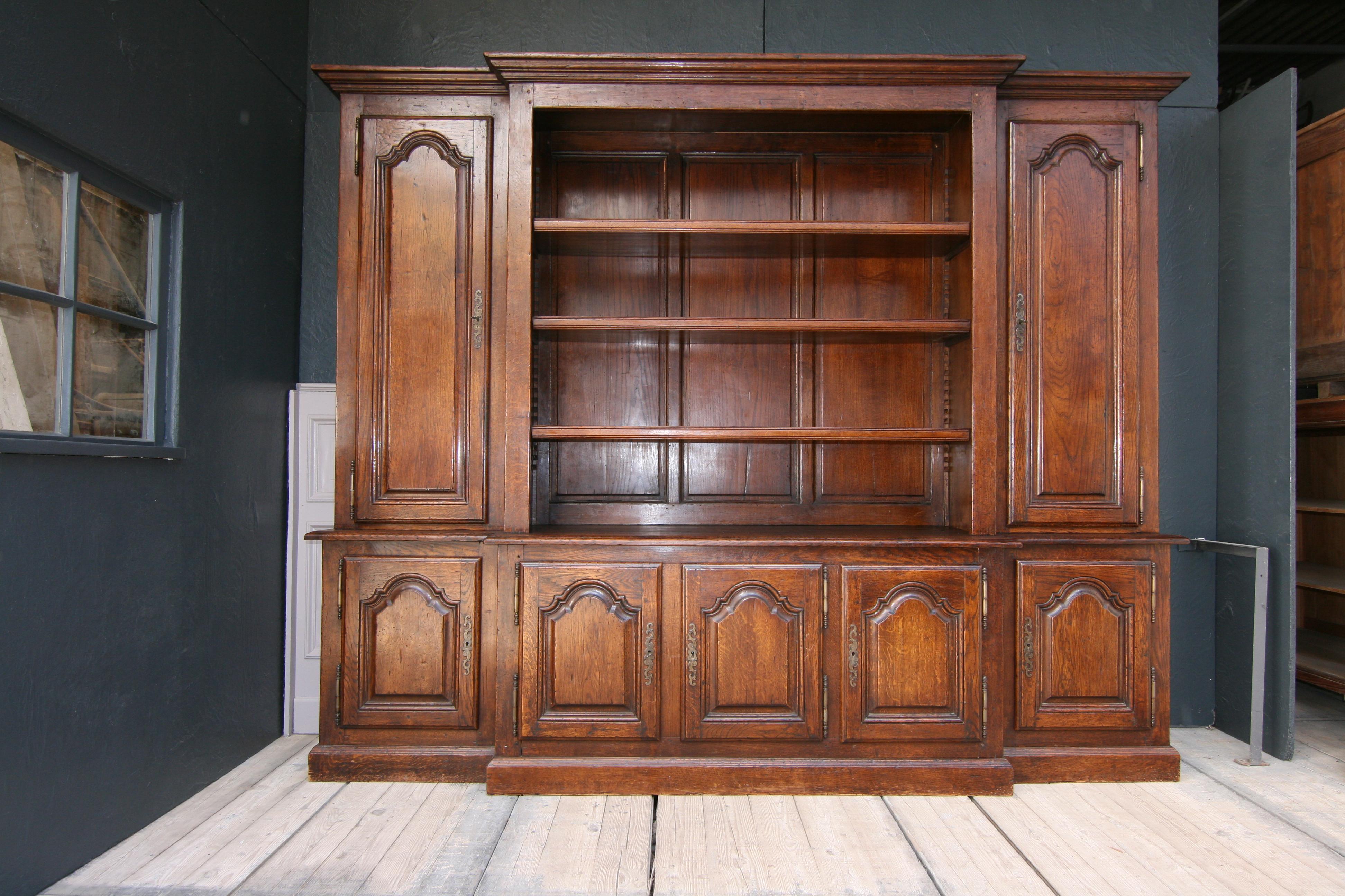 Large, high-quality French bookcase or cupboard from the 20th century, made of solid oak.

Lower part with 5 doors, behind which there are shelves.

Upper part with 2 large doors, each with 3 adjustable shelves, and a large open part in the
