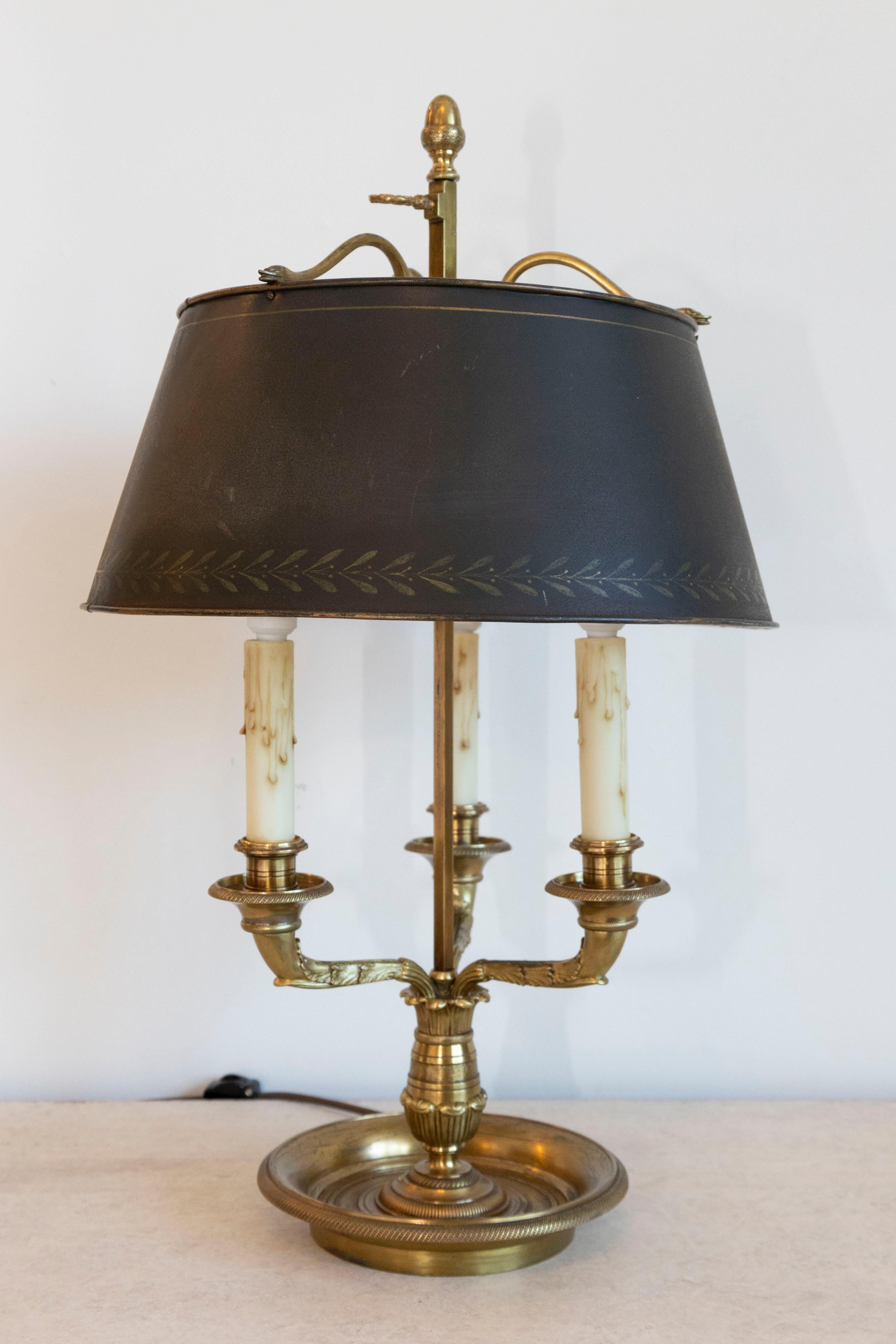 Ejemplo refinado de la iluminación francesa de principios del siglo XX, esta lámpara Bouillotte desprende elegancia atemporal con su marco de latón finamente fundido y su característica pantalla de tôle (metal pintado) negra. Diseñada originalmente
