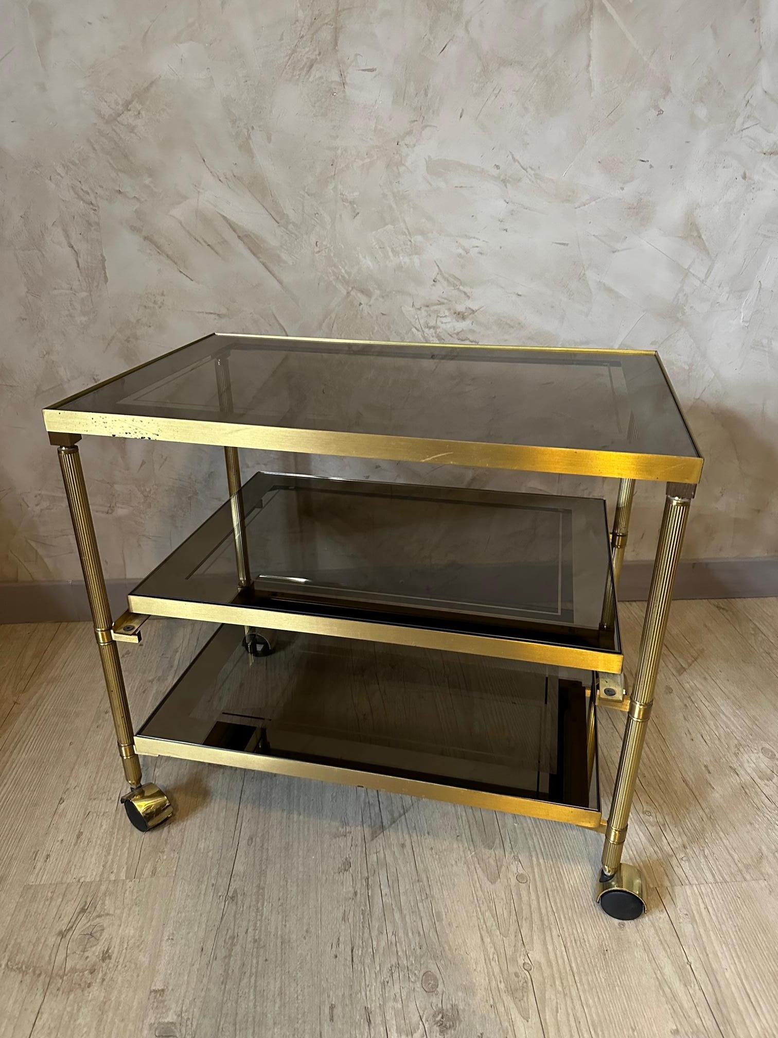 Very nice vintage dessert table from the 70s in brass and removable trays in smoked glass. Sliding middle shelf. Nice quality and good condition.