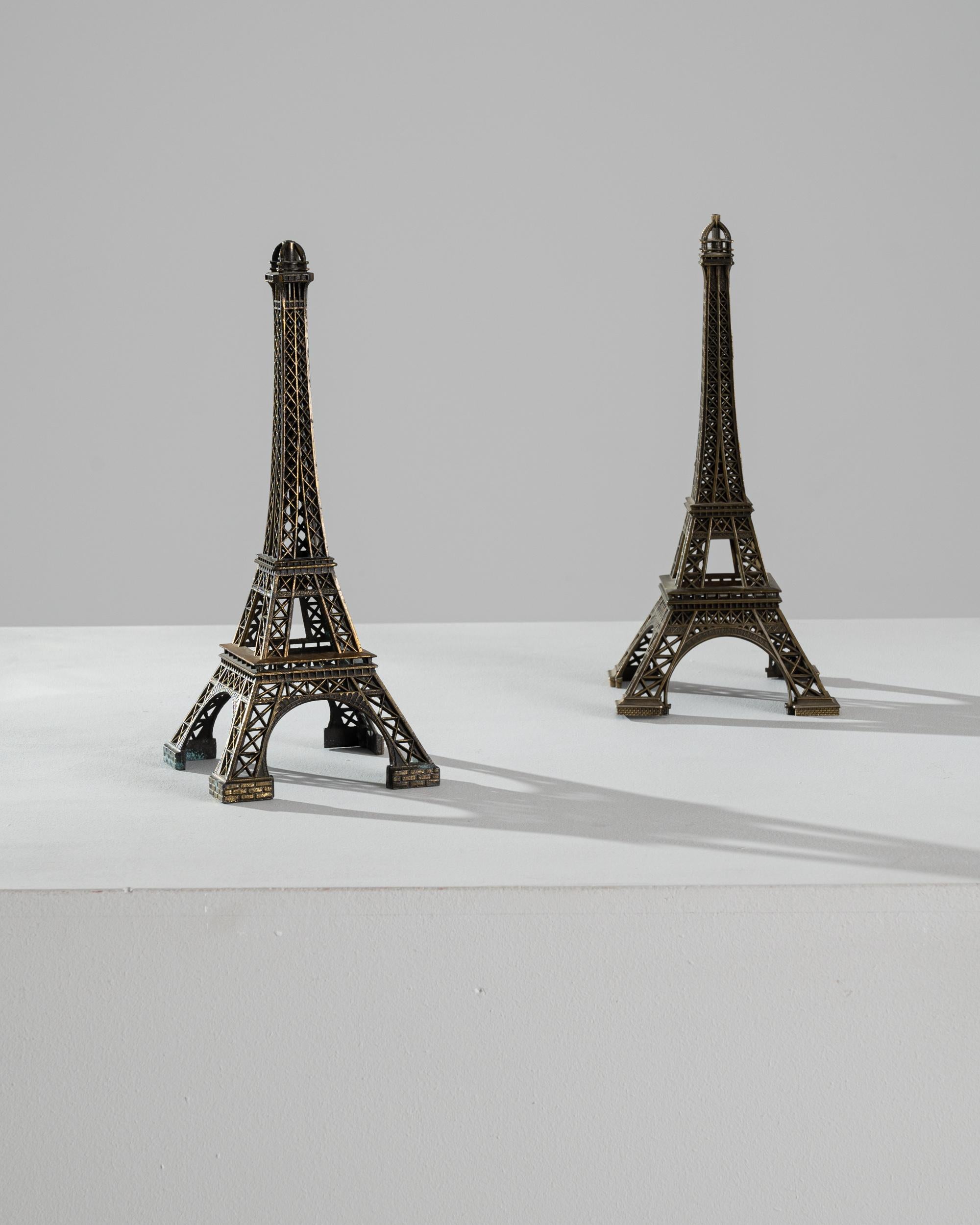 This pair of brass decorations in the shape of the Eiffel tower conjures the romance of a voyage to Paris. Made in France in the 20th Century, the intricate lattice-work is rendered in perfect detail, bringing the iconic monument to life. The dark