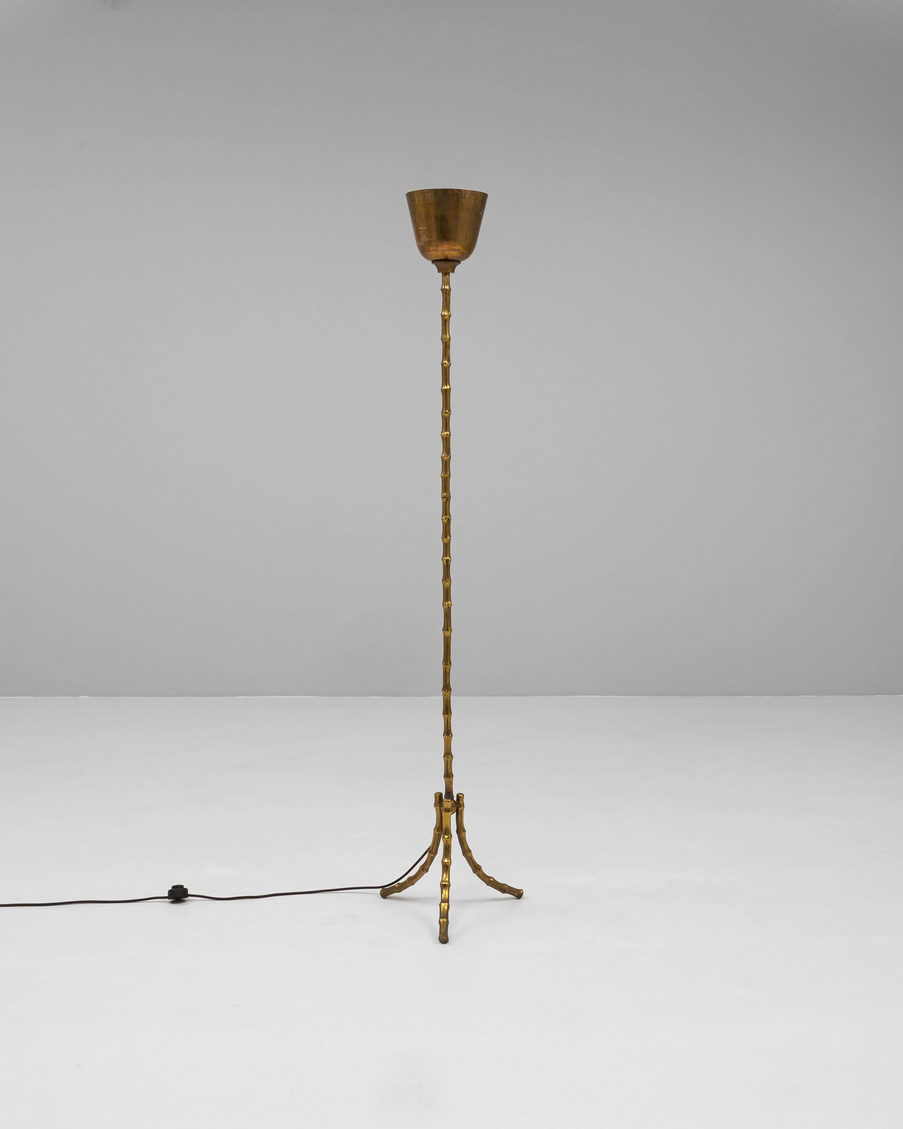 Diese Stehlampe aus französischem Messing des 20. Jahrhunderts ist ein raffiniertes Einzelstück, das skulpturale Eleganz mit funktionalem Design verbindet. Der Sockel und der Stiel sind im Stil einer Bambusattrappe gefertigt und weisen strukturierte