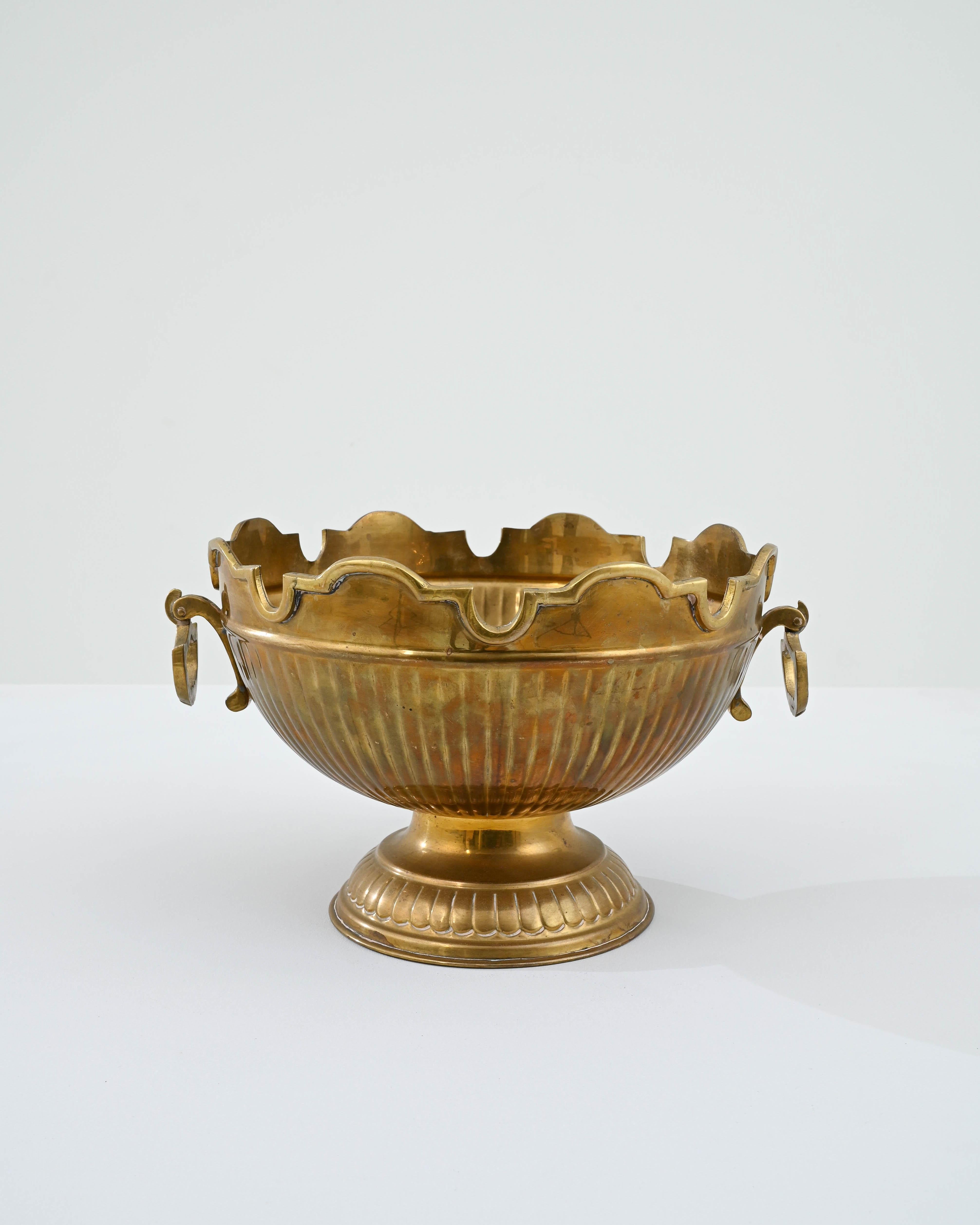 A metal ice bucket created in 20th century France. With gracefully sculpted handles and a pleasantly designed upper ring, this dignified bowl possesses an air of kingly regality. The delicately patterned exterior walls of the bowl shimmer and behold