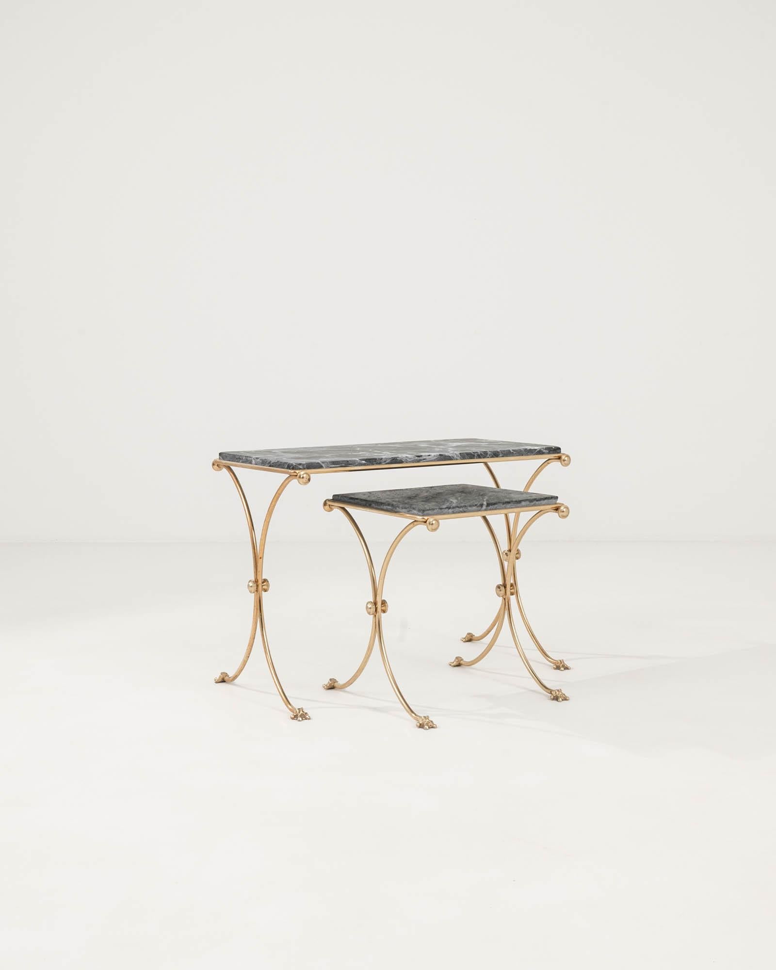 Introducing our exquisite 20th Century French Brass & Marble Nesting Tables, a luxurious addition to any living space. Crafted with meticulous attention to detail, this set of two tables showcases the timeless elegance of antique design. Each table