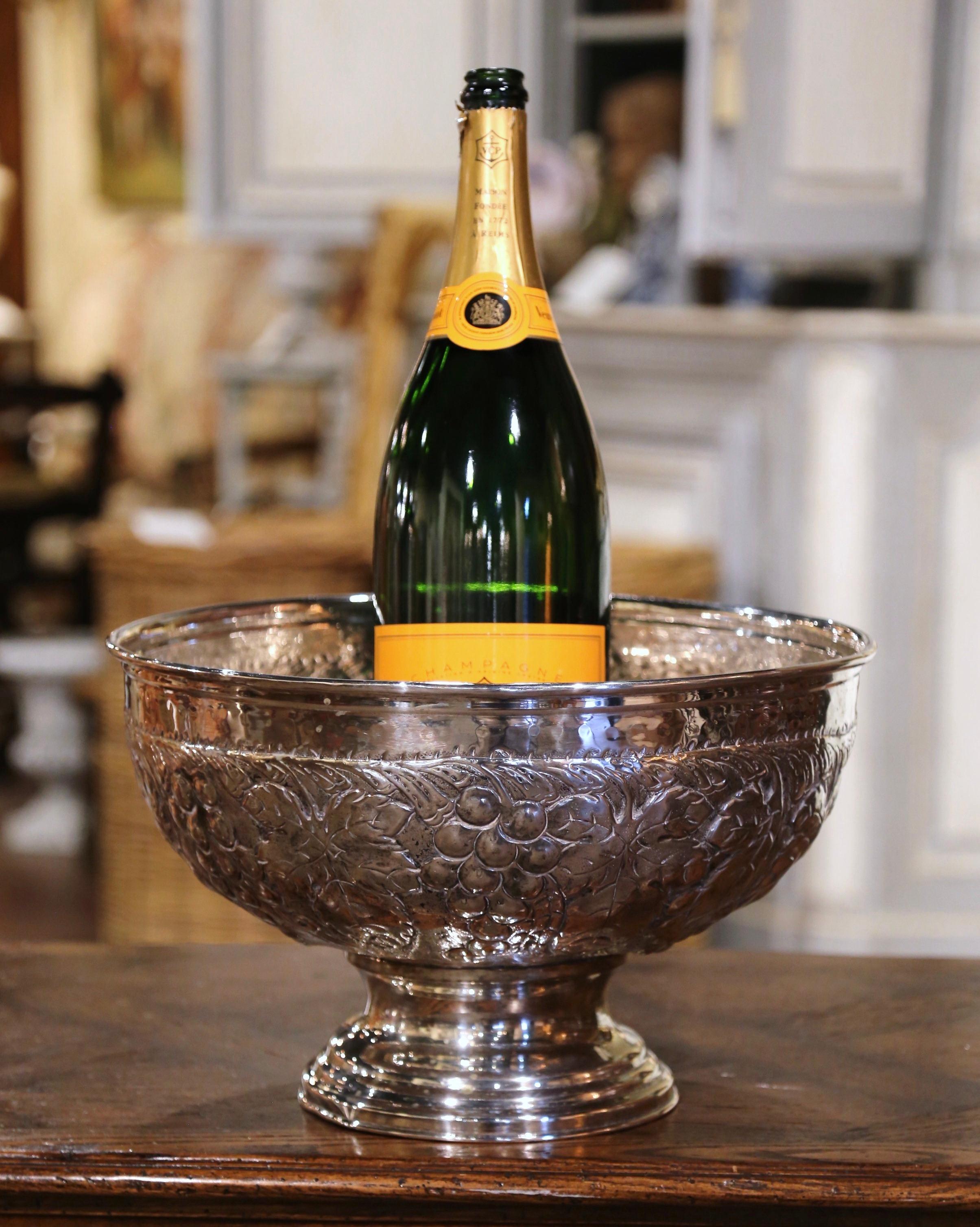 Chill your favorite Sauvignon Blanc or Veuve Clicquot in style in this elegant cooler bucket! Crafted in France circa 1970 and circular in shape, the bowl features intricate repousse grape and vine motifs throughout. An additional pierced tray with