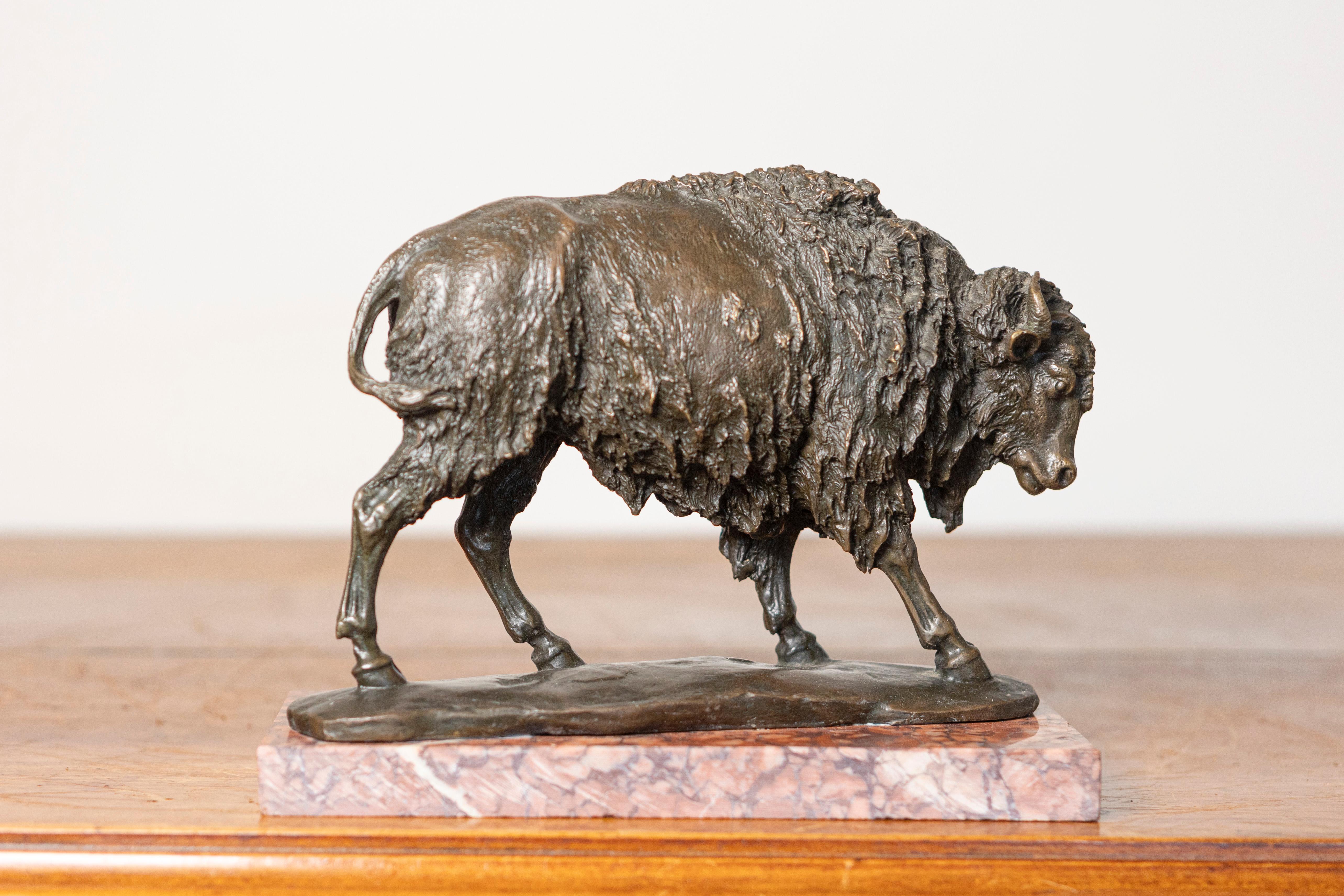 Questa straordinaria scultura in bronzo francese del XX secolo raffigura un maestoso bisonte in piena corsa, mostrando un realismo e un'attenzione ai dettagli impressionanti. La superficie strutturata del bronzo cattura magistralmente il pelo folto