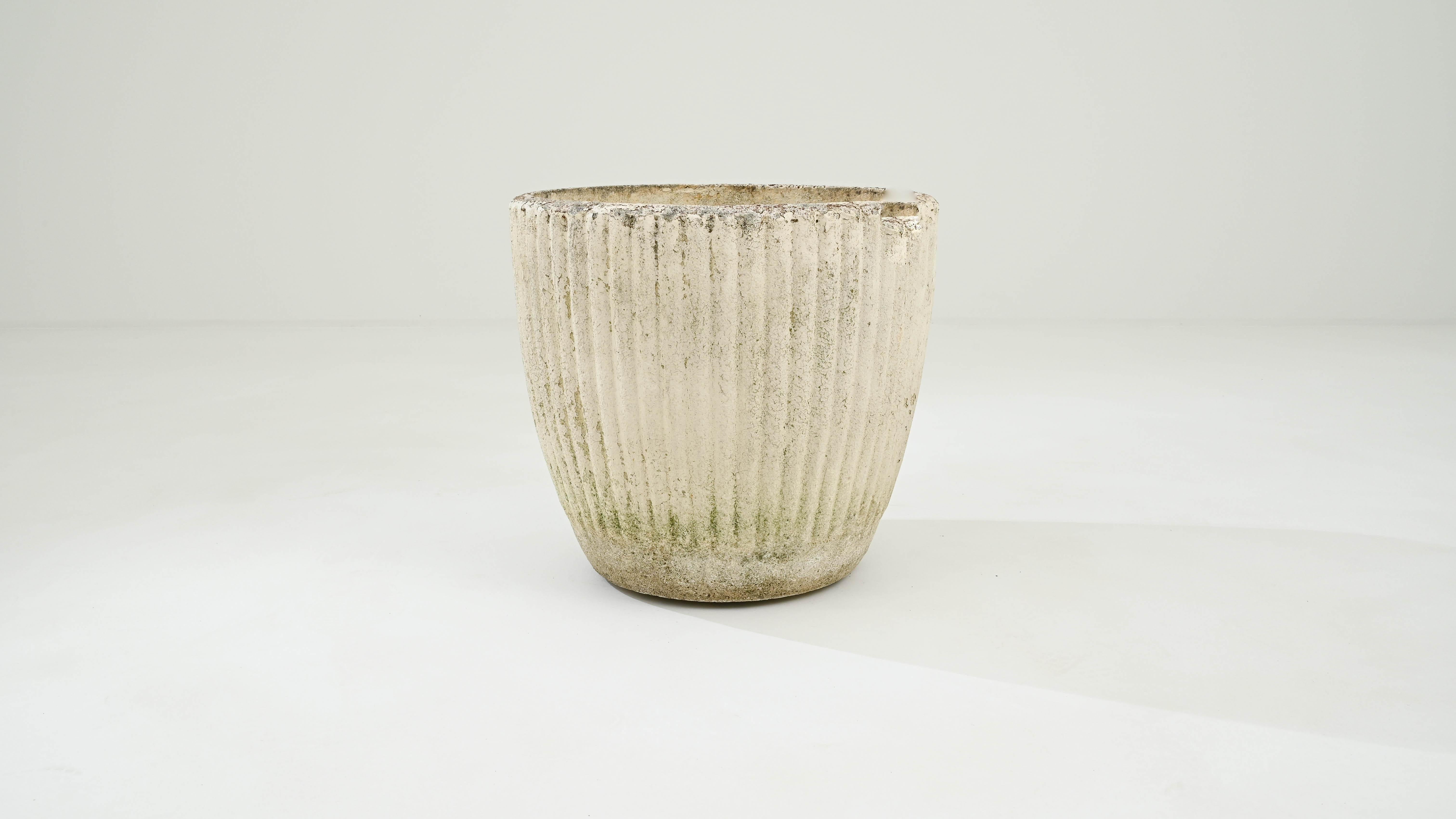 This brutalist concrete planter was designed in France during the 20th century. The attractive, riffled texture of its surface is punctuated by a weathered patina. Originally ivory white, over time, it has acquired a subtle green hue on the sides,