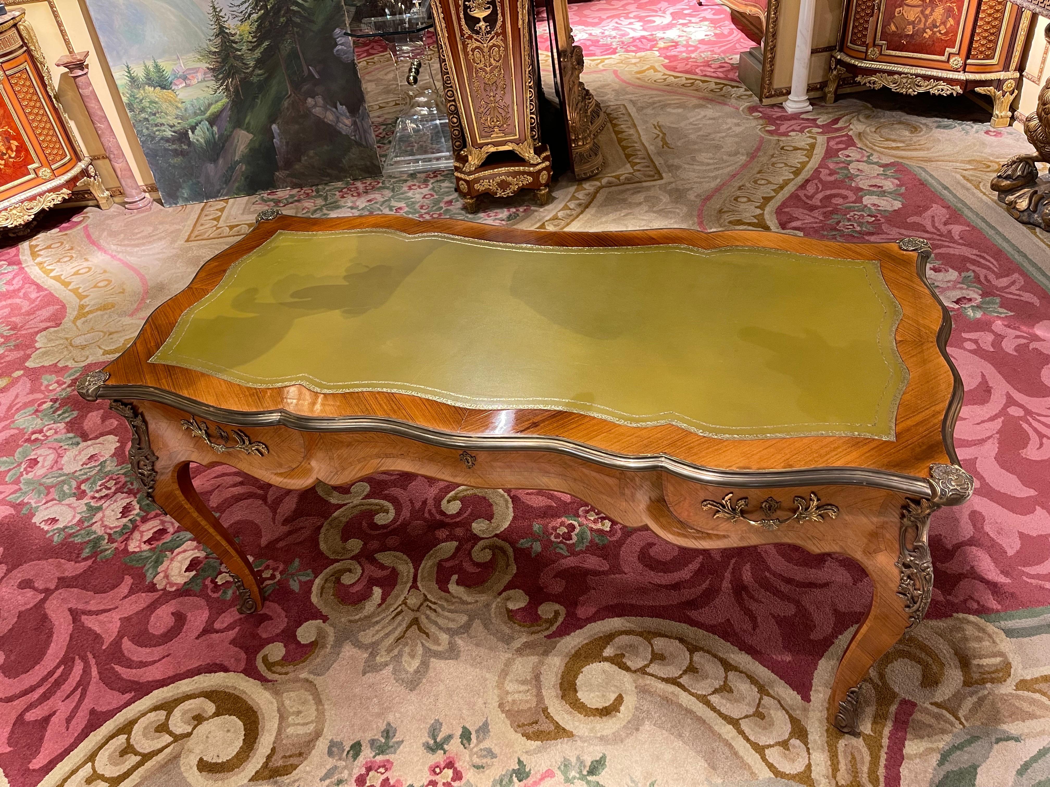 20th century French bureau plat/ writing desk 

In Bois Satiné veneer, mirror veneer covering all sides with rocaille applications. Edged with extremely finely chiselled, extremely decorative, restrained bronze fittings. Tulip veneer on solid