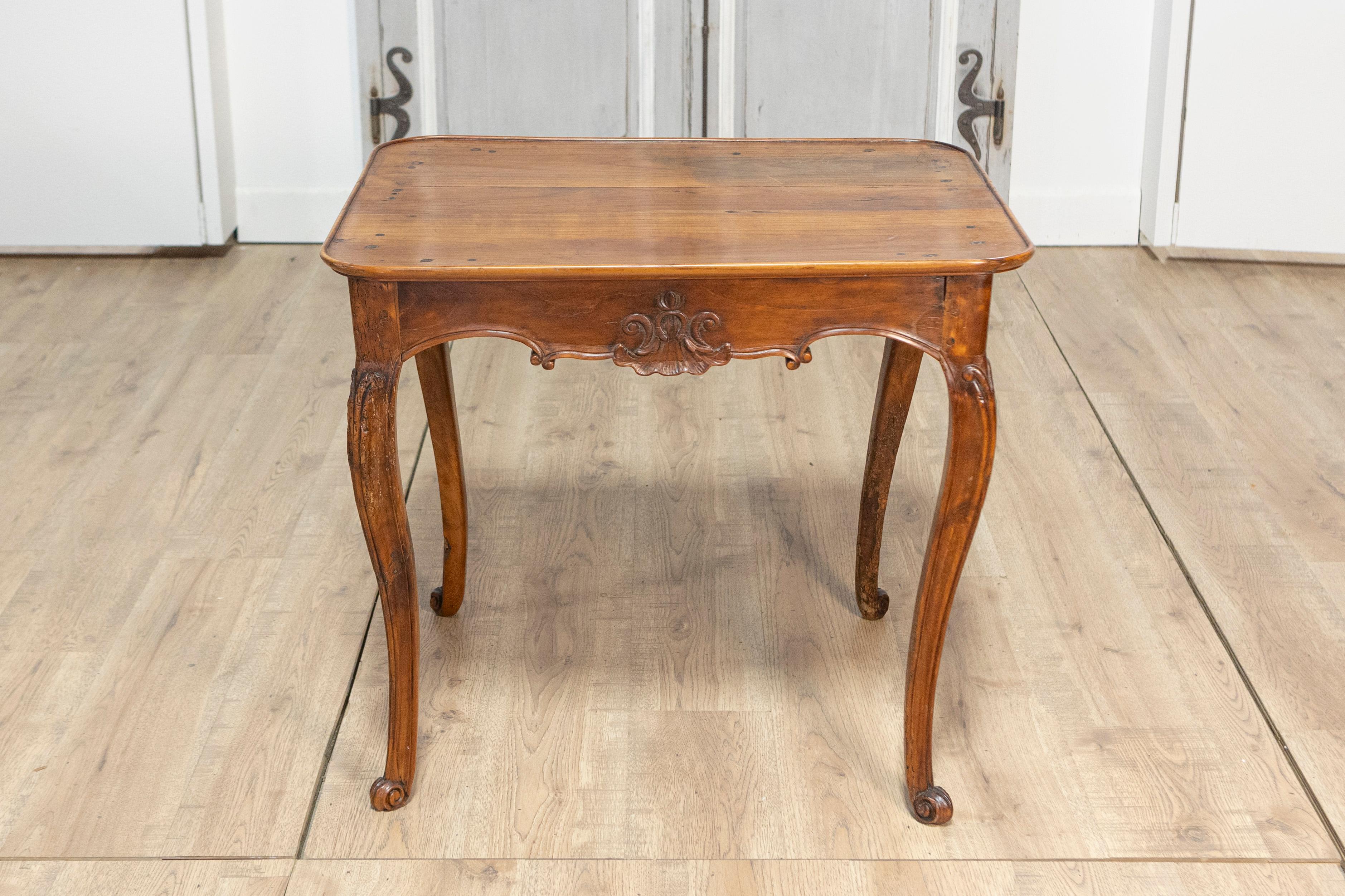Esta elegante mesa de cabaret francesa del siglo XX es un ejemplo de artesanía y encanto intemporales. Fabricada en nogal macizo, la mesa luce una pátina cálida y rica que resalta la belleza natural de las vetas de la madera. Su parte superior