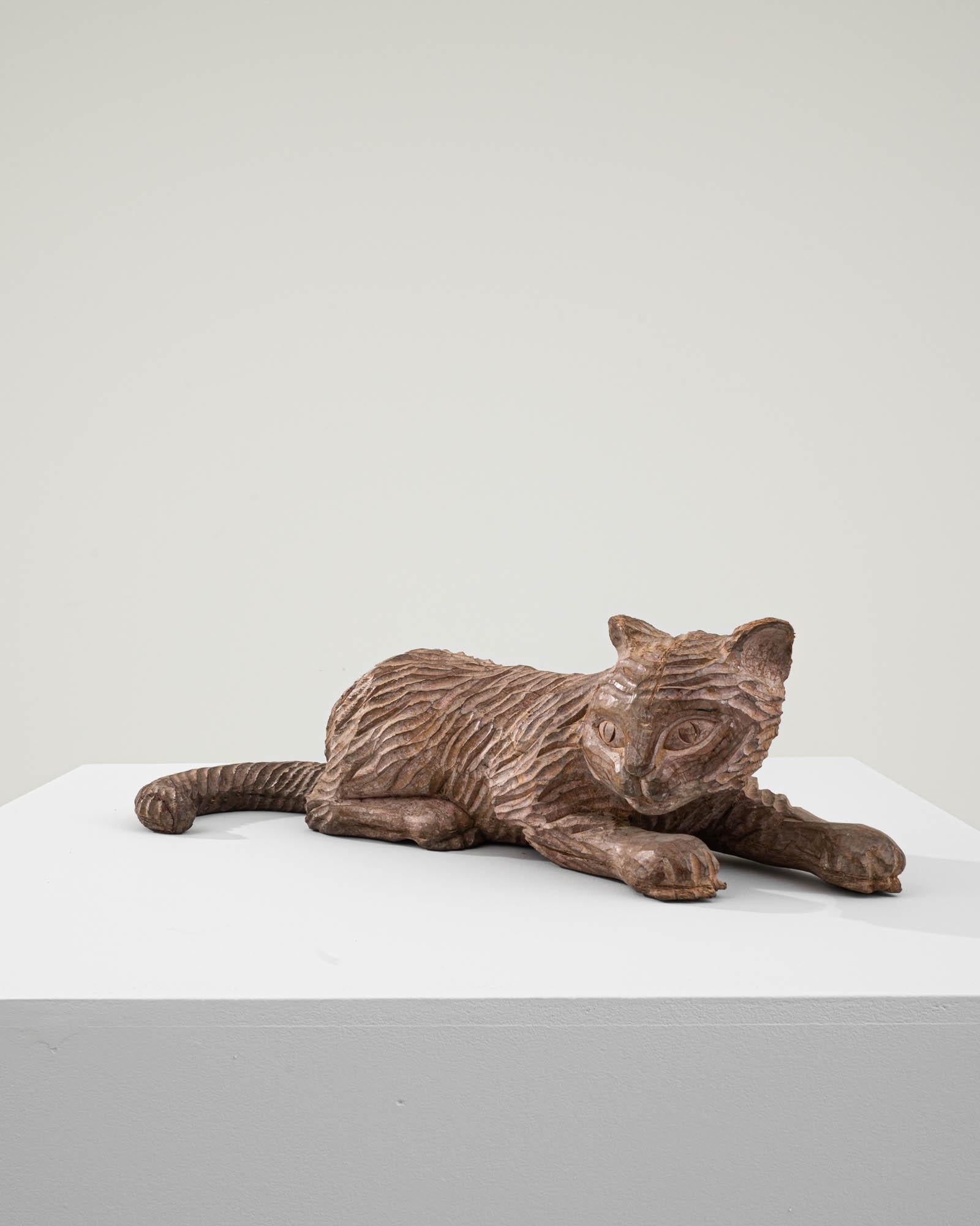 Lassen Sie sich vom Charme dieser geschnitzten französischen Holzkatze aus dem 20. Jahrhundert verzaubern. Diese mit viel Liebe zum Detail gefertigte, liegende Katzenfigur strahlt eine Aura der Entspannung und Zufriedenheit aus. Die aufwändige
