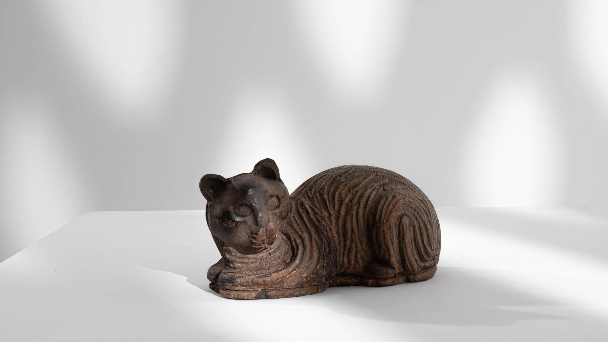 Capturing the essence of feline grace, this 20th-century French Carved Wooden Cat Decoration radiates charm and whimsy. Crafted with intricate details, the small and cute cat is depicted in a sphinx position, with a defined mouth, delicate whiskers,