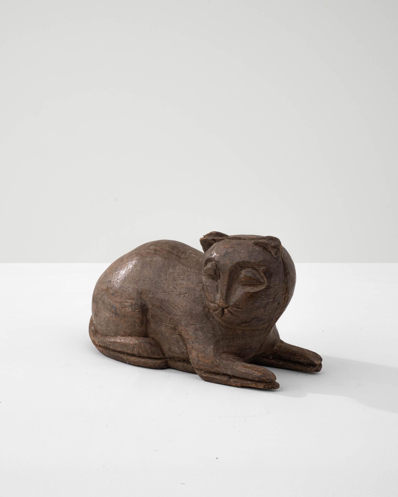 Radiating an aura of feline charm and innocence, this 20th-century French Carved Wooden Cat Decoration captures the essence of a cat in a sphinx position. The smooth wooden surface showcases meticulous detailing, with the cat's eyes and ears
