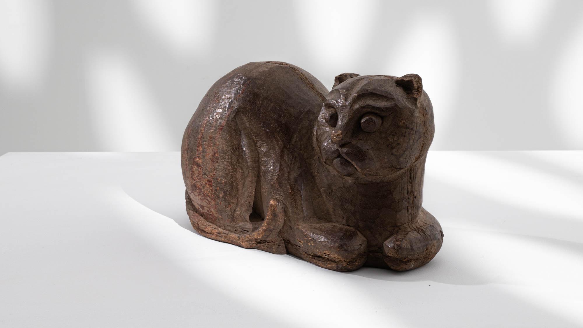 Gracefully poised in a sphinx position, this 20th-century French Carved Wooden Cat Decoration captivates with its arched back and distinct facial features. The intricately carved round face and well-defined mouth lend a unique charm to this vintage