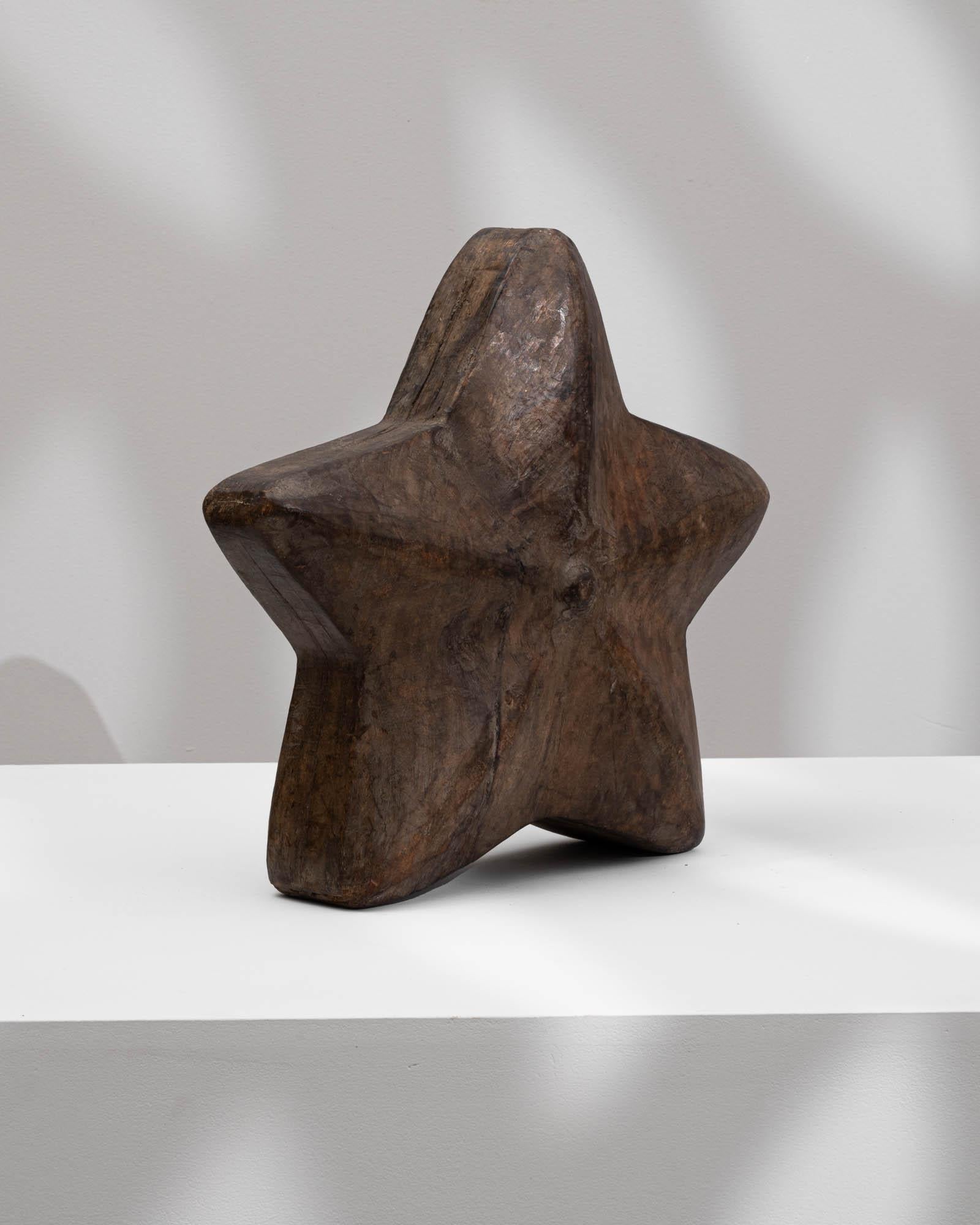 Elevate your décor with the enchanting presence of this 20th Century French Carved Wooden Star Decoration. Crafted from dark wood, the star exudes a timeless elegance that seamlessly integrates into various design aesthetics. With a skillfully
