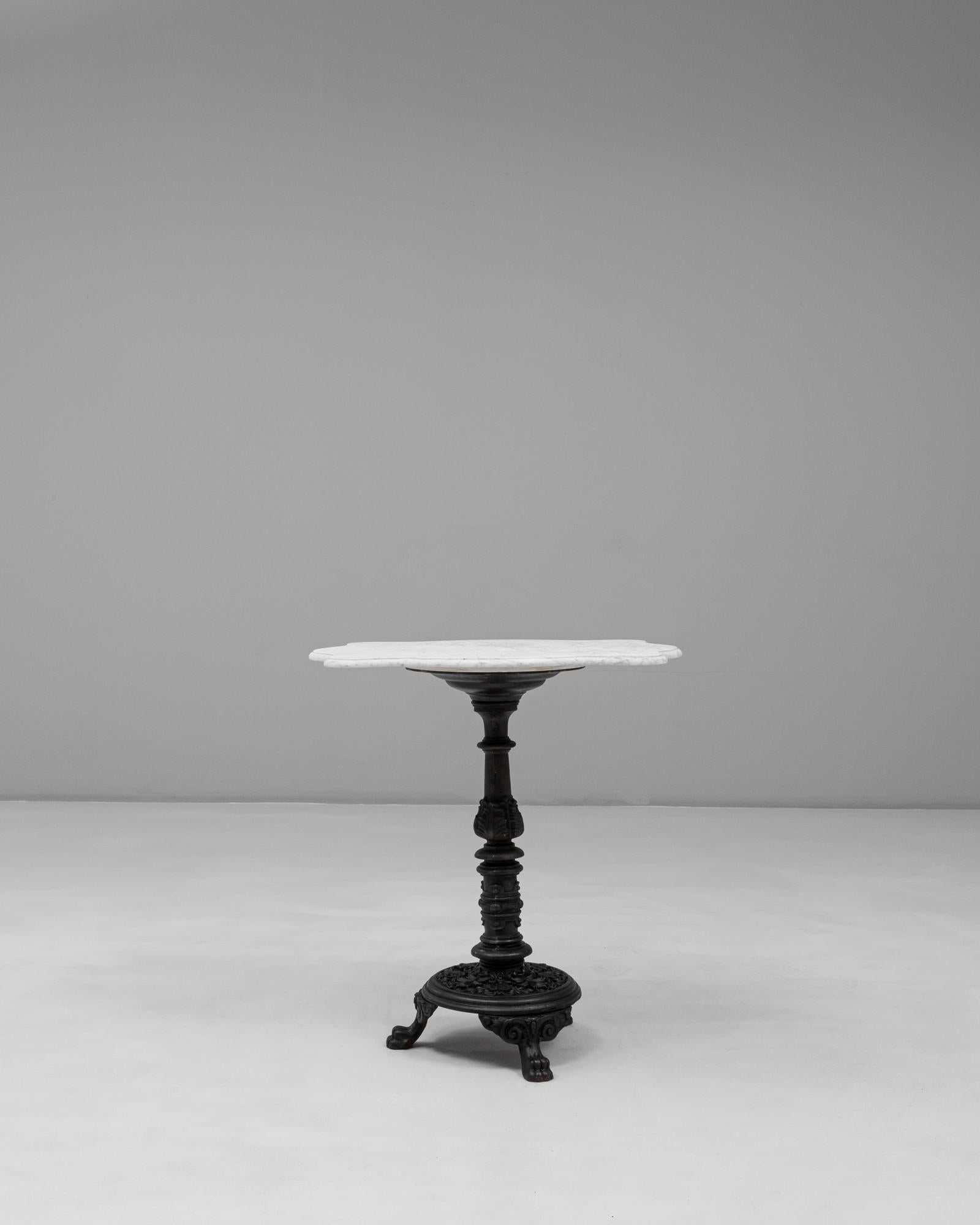 Cette table de bistrot française en fonte du 20e siècle avec plateau en marbre allie le style classique des cafés et des matériaux durables et éprouvés. Le plateau en marbre blanc, aux formes douces avec des veines naturelles et une légère usure de