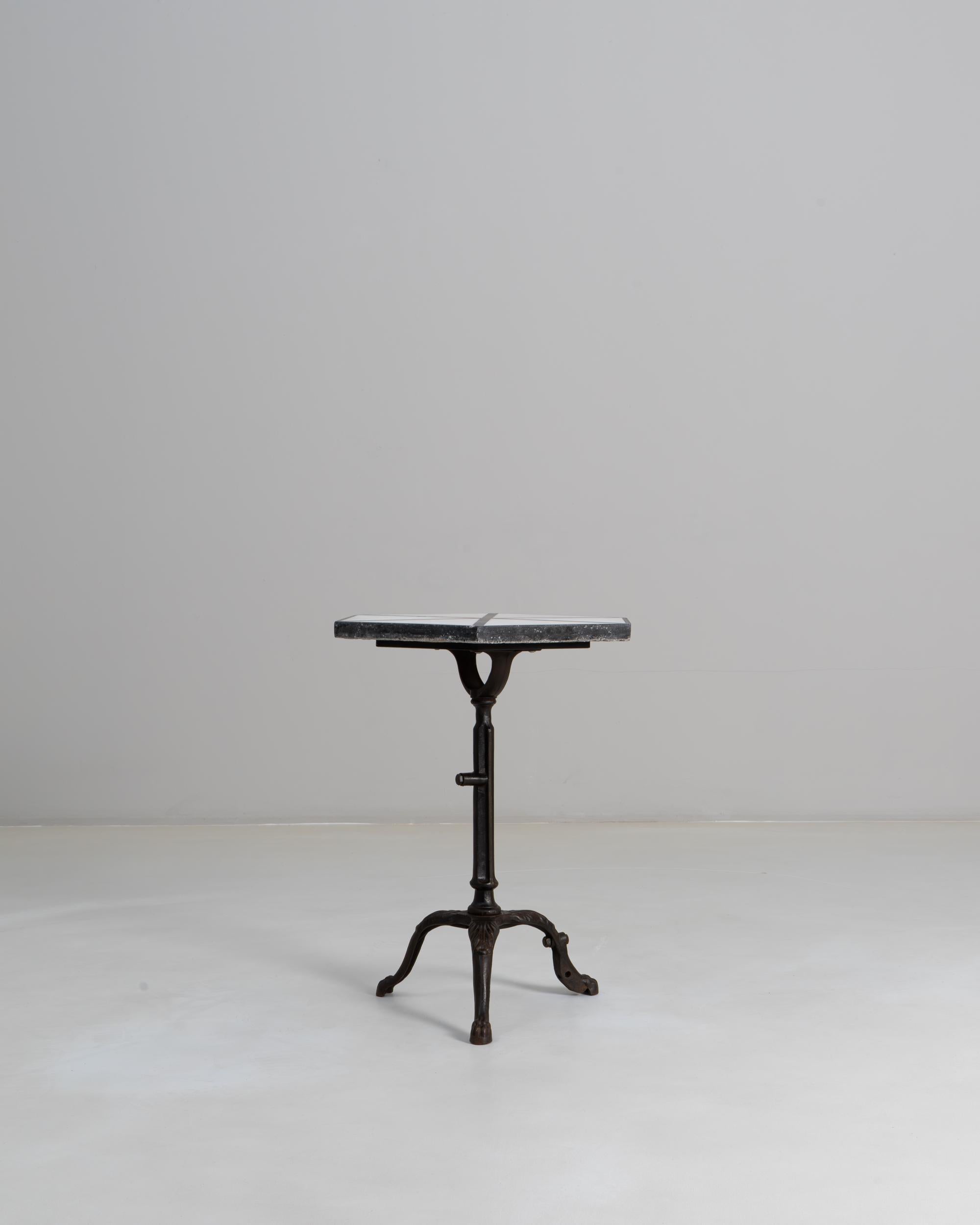 This 20th Century French cast iron bistro table with a marble top captures the charm and durability of classic café furnishings. The square marble surface shows natural veining and gentle wear, offering a timeless contrast to the dark cast iron