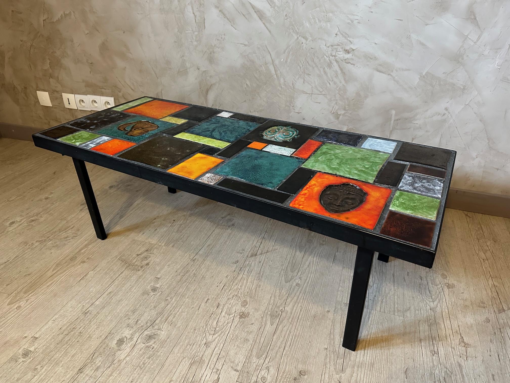 Very beautiful coffee table from the 60s in ceramic tiles and black metal base.
Very colorful ceramic tiles, three of them represent African heads or masks.
Very good state. For lovers of mid-century design and furniture.
