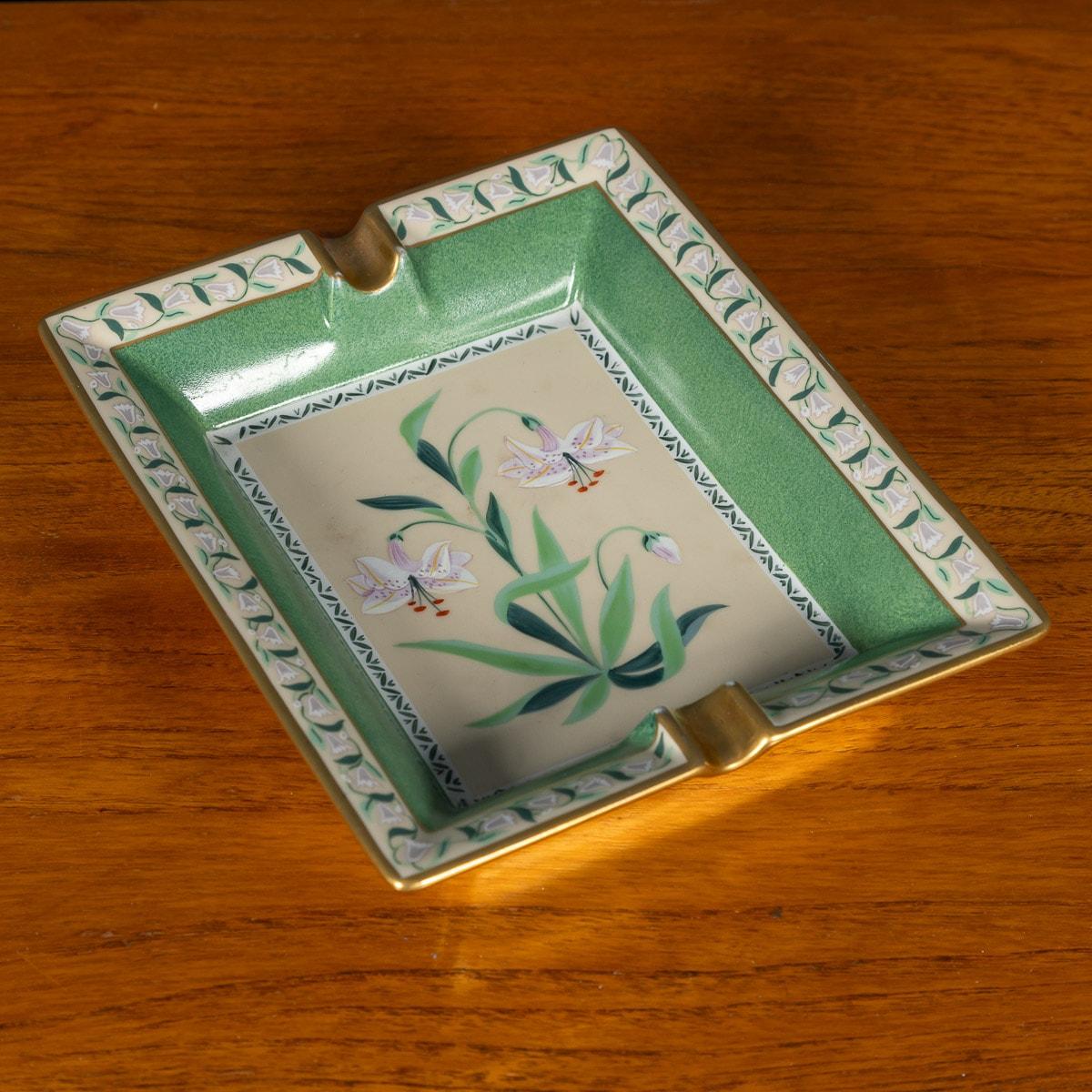 A ceramic ashtray by Hermes, made in France in the latter half of the 20th century. These ashtrays have always been very collectable with the vintage models in particular. This one has a lovely floral theme (white lillies) but at the same time
