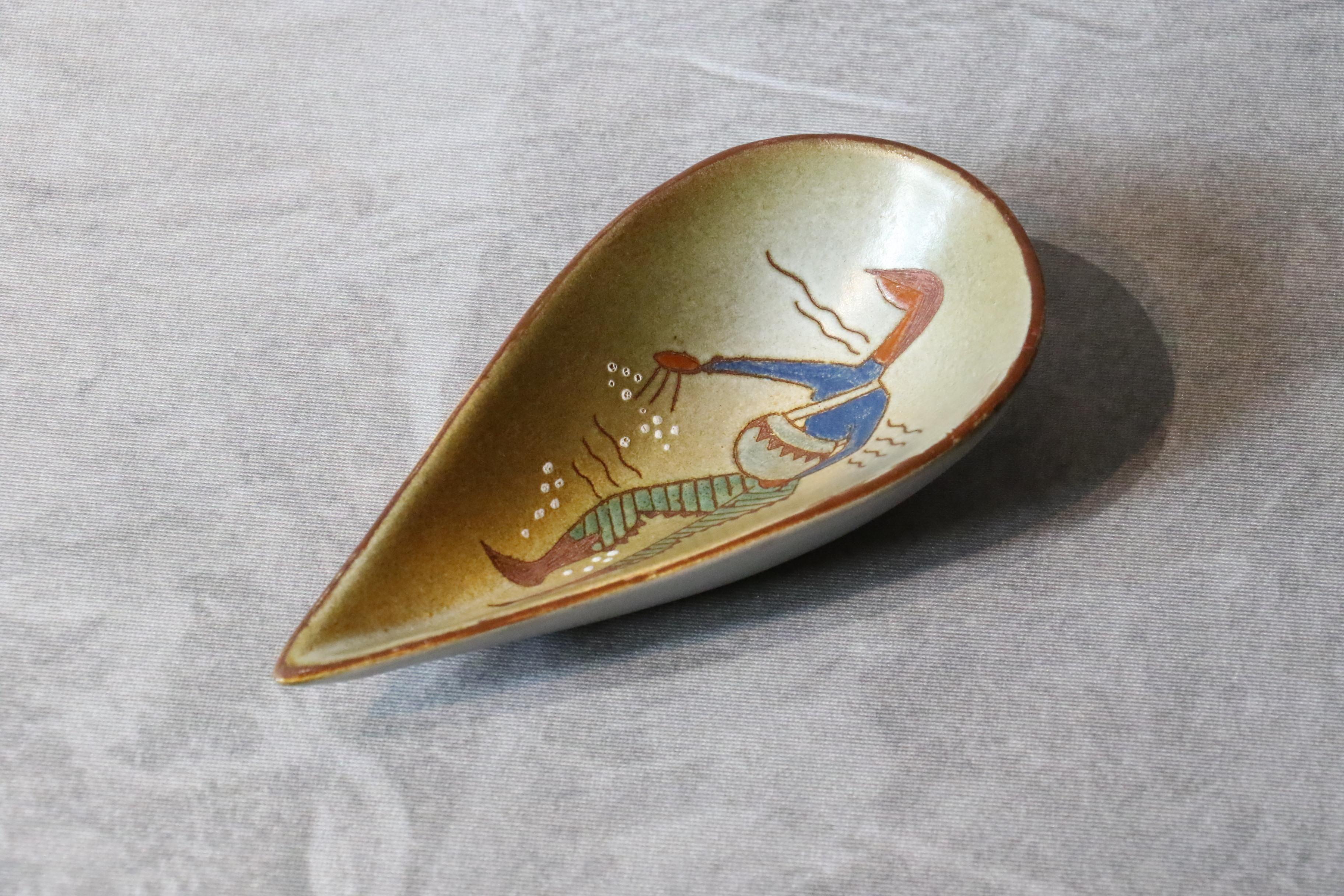 tasse en céramique blanche française du 20e siècle par René Maurel, années 1970.

Cette tasse en céramique est finement décorée d'un homme qui sème. Le bol est émaillé d'un ton ocre et de bordures brunes. 
Elle est signée ci-dessous. 
Il est en