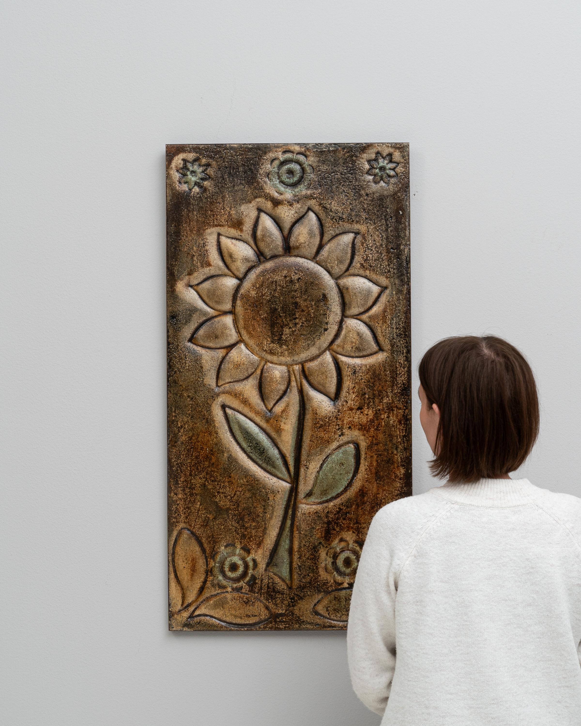 This 20th Century French Ceramic Wall Decoration embodies the timeless allure of artisan craftsmanship. Featuring a beautifully stylized sunflower motif, this piece exudes a rustic charm that captures the essence of French country aesthetic. The