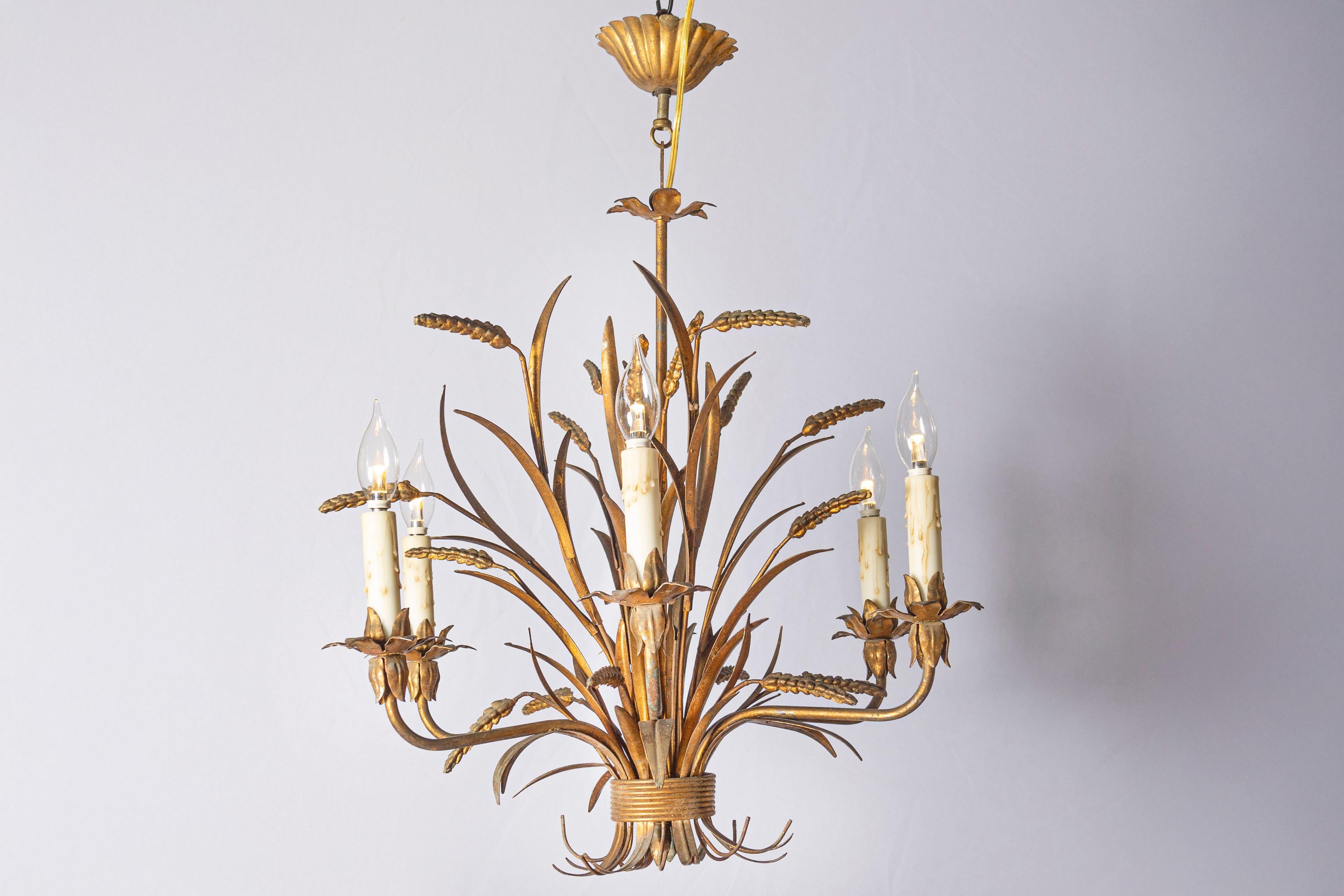 Cet élégant lustre français du XXe siècle, inspiré par le style emblématique de Coco Chanel, présente un magnifique motif naturaliste de gerbe de blé, qui était l'un des symboles préférés de Chanel. Le lustre présente une structure en métal doré