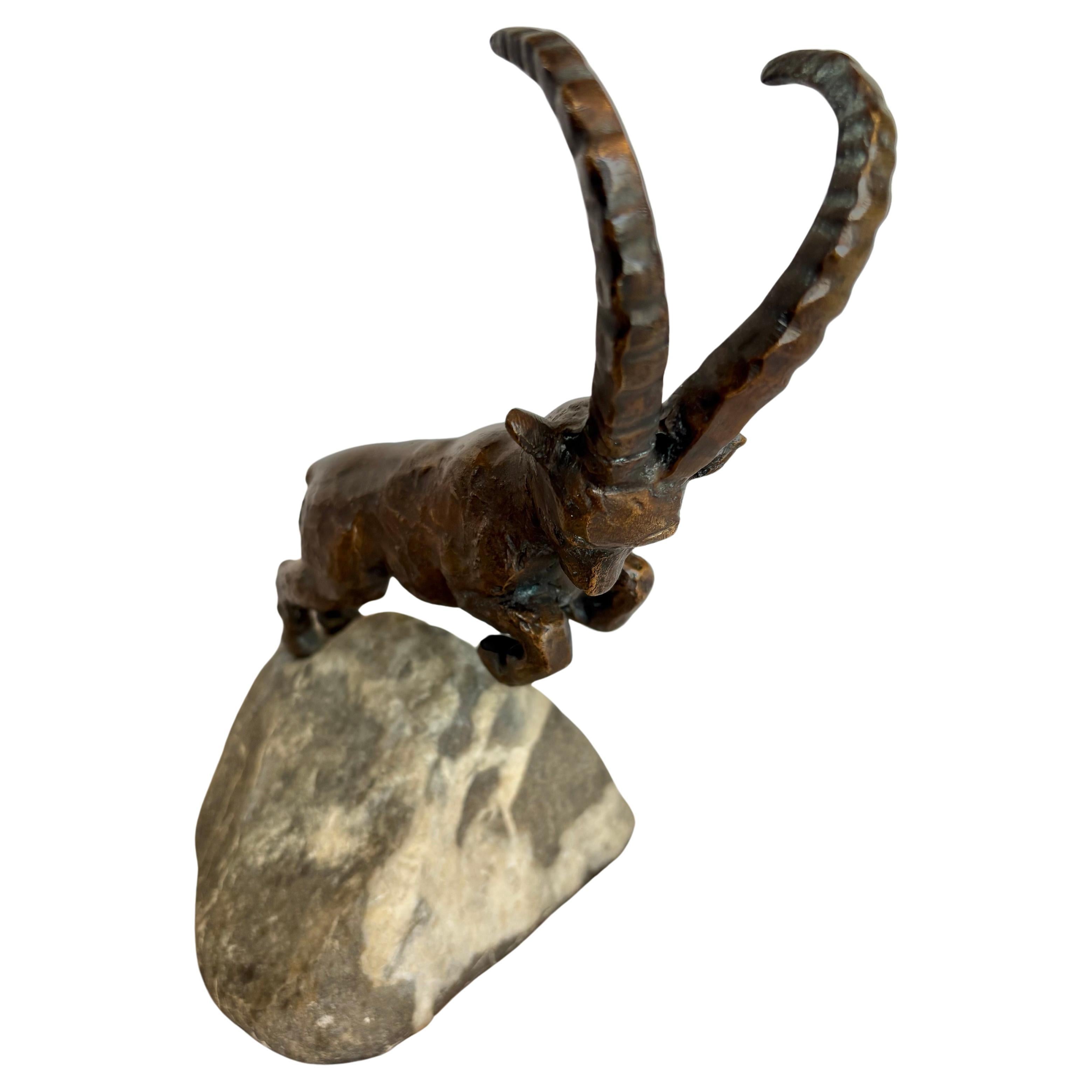 Questa potente scultura di stambecco in bronzo del XX secolo è opera dell'artista francese Charles Reussner (1886-1961). Reussner era molto conosciuto e ricercato per le sue sculture. Il pezzo raffigura una capra di montagna stilizzata con una