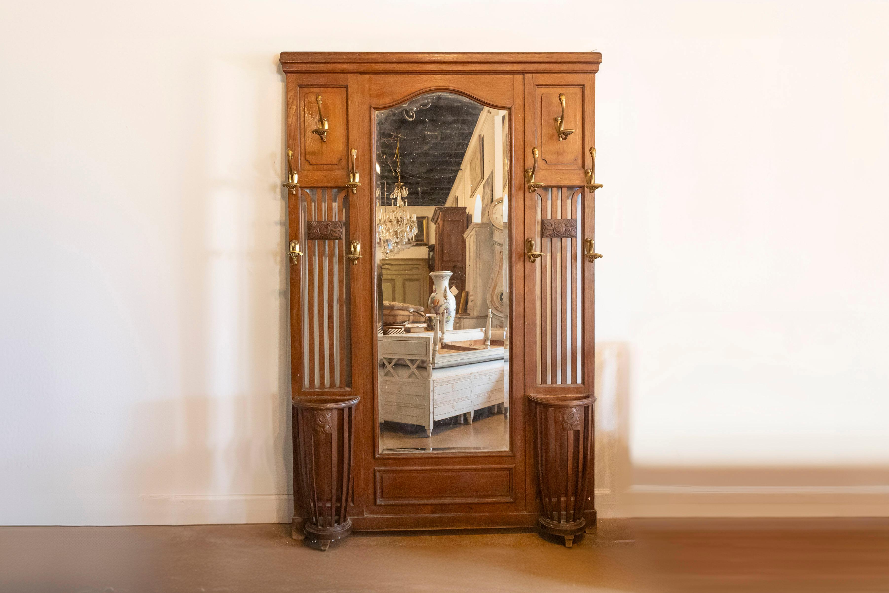 Questo bellissimo appendiabiti francese del XX secolo incarna il classico artigianato francese con un mix di stile e funzionalità. Realizzato in legno caldo e ricco, presenta un bellissimo specchio centrale alto, perfetto per un rapido controllo