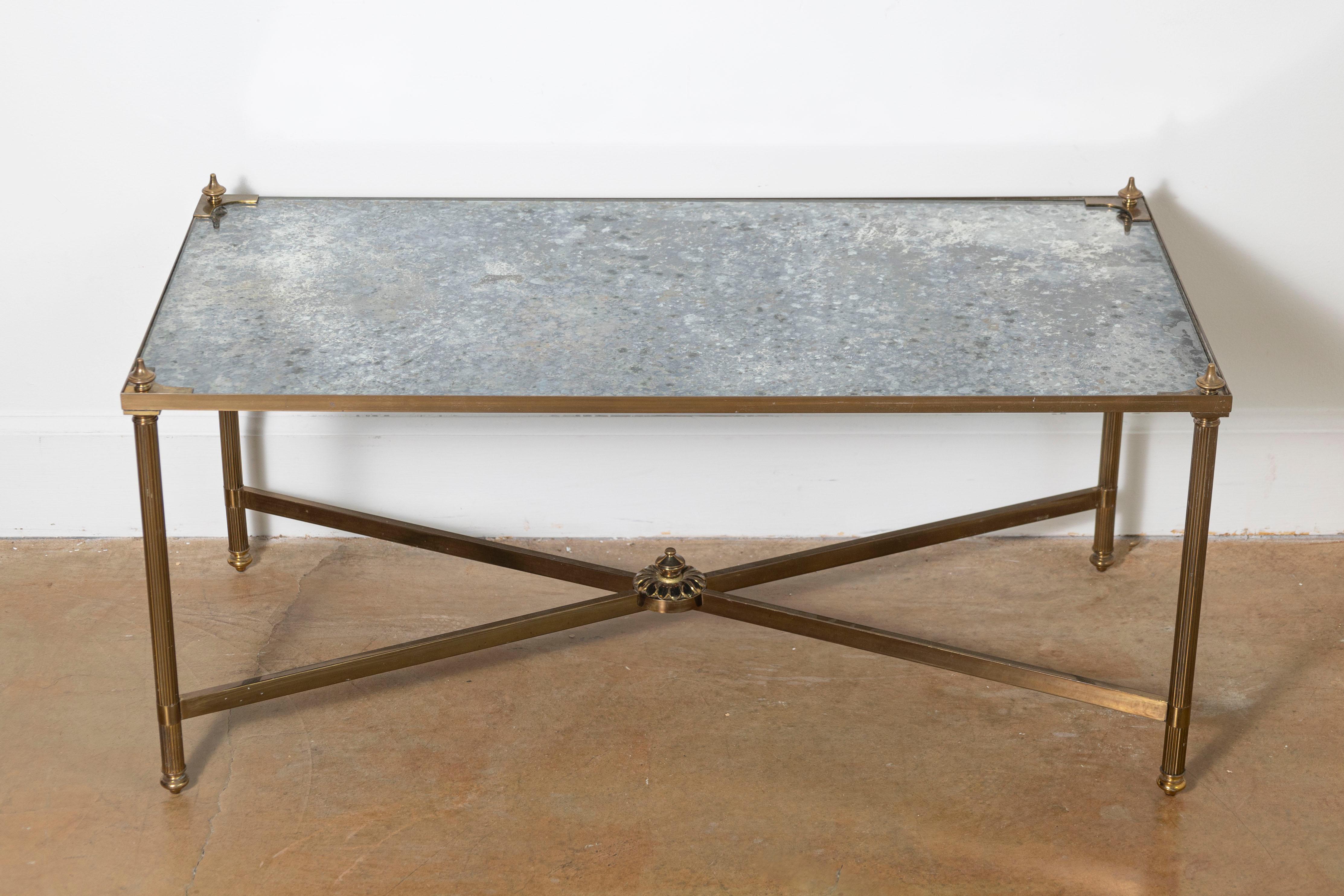 Questo splendido tavolino francese del XX secolo conferisce un'eleganza e una raffinatezza senza tempo a qualsiasi spazio. Il tavolo ha un design elegante e rettangolare con un bellissimo piano a specchio anticato che aggiunge profondità e una