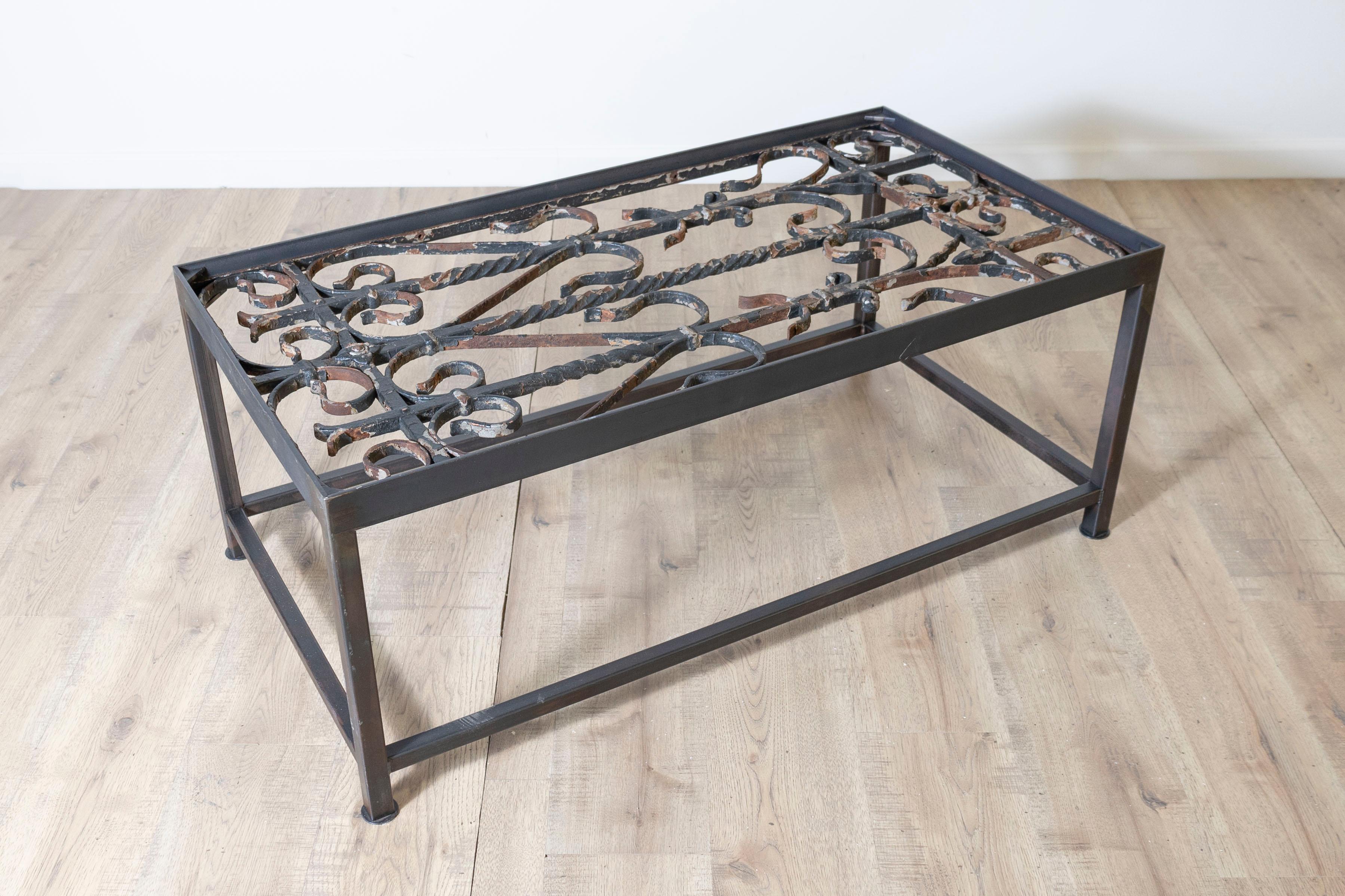 Cette table basse unique réutilise d'anciens garde-corps de balcons français pour en faire une œuvre d'art fonctionnelle saisissante. Le plateau de la table présente un travail de ferronnerie complexe, mettant en valeur des motifs géométriques et