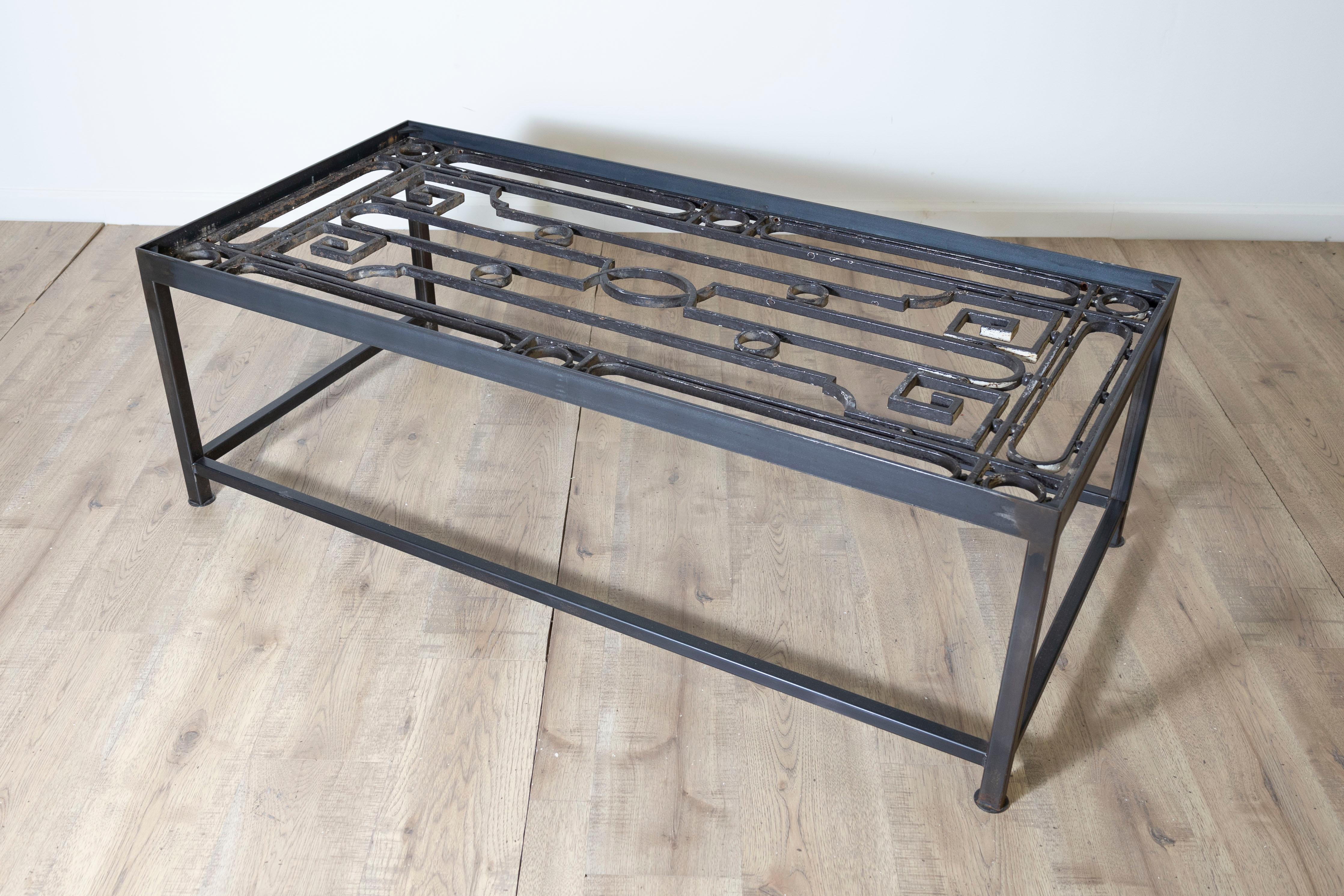 Cette table basse unique réutilise d'anciens garde-corps de balcons français pour en faire une œuvre d'art fonctionnelle saisissante. Le plateau de la table présente un travail de ferronnerie complexe, mettant en valeur des motifs géométriques et