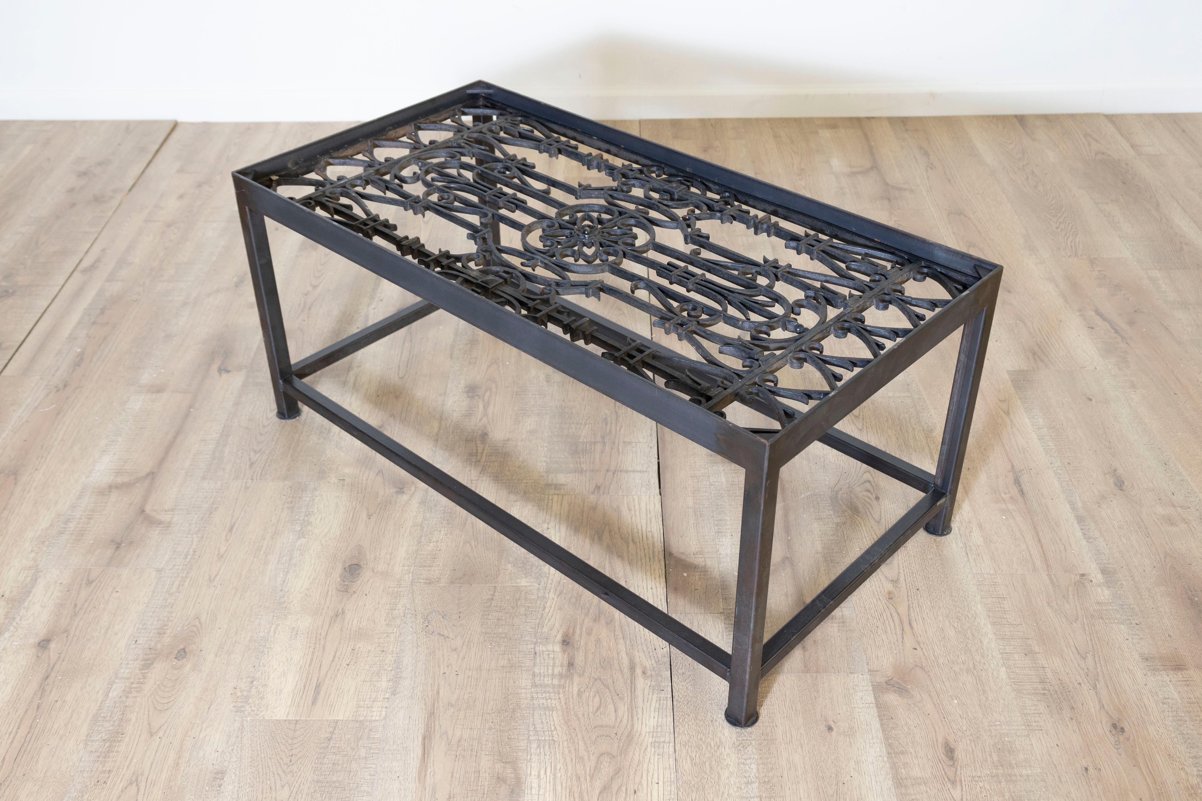 Cette table basse unique réutilise d'anciens garde-corps de balcons français pour en faire une œuvre d'art fonctionnelle saisissante. Le plateau de la table présente un travail de ferronnerie complexe, mettant en valeur des motifs géométriques et