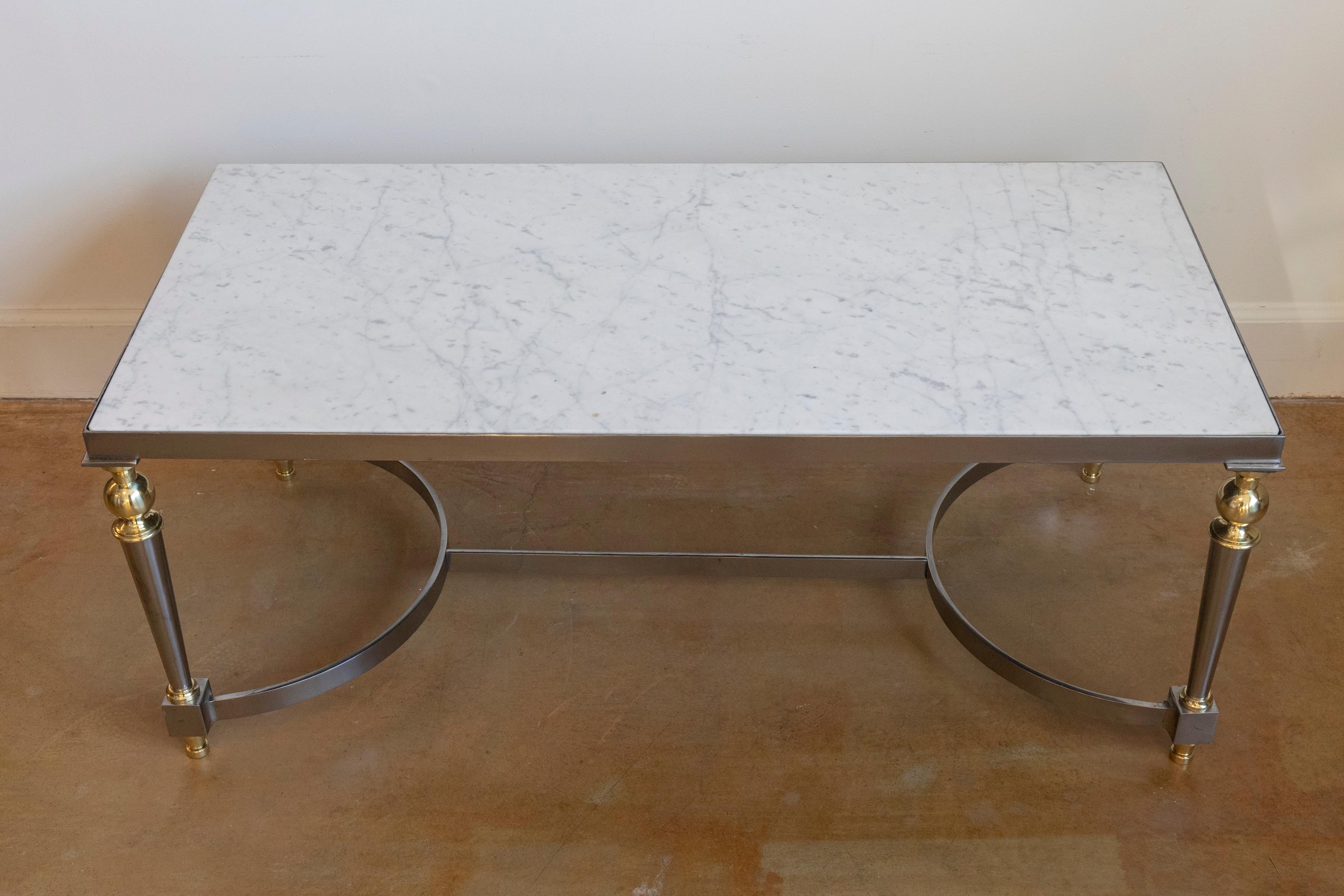 Cette table basse française sophistiquée du XXe siècle est un exemple frappant d'élégance moderniste combinée à des influences classiques. Whiting d'un élégant plateau rectangulaire en marbre blanc avec des veines naturelles, cette pièce respire le