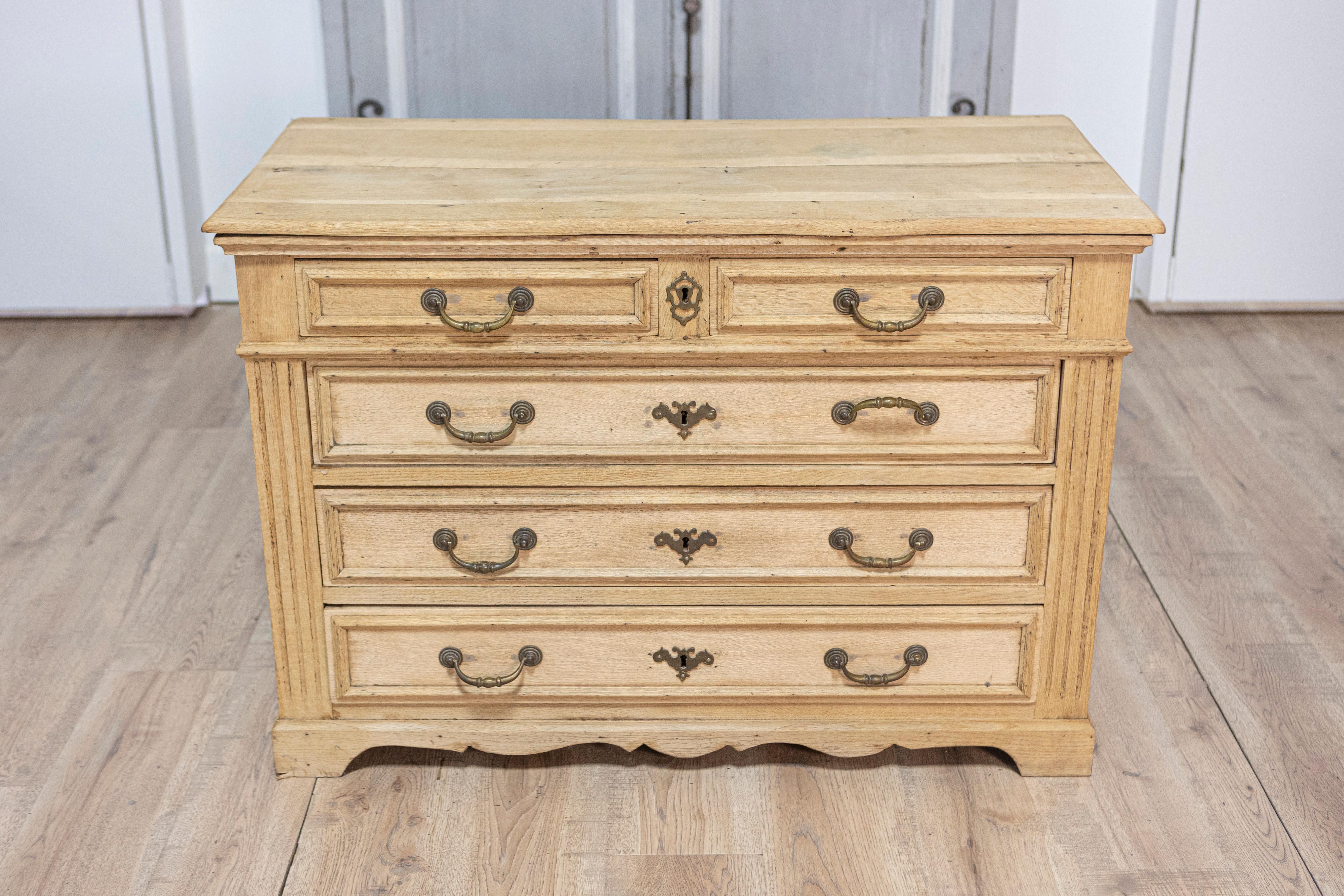 Questa incantevole commode francese del XX secolo incarna lo stile Luigi XV, mostrando l'eleganza dell'artigianato tradizionale combinata con un design funzionale. Realizzato in legno di quercia, il comodino presenta una calda finitura naturale che