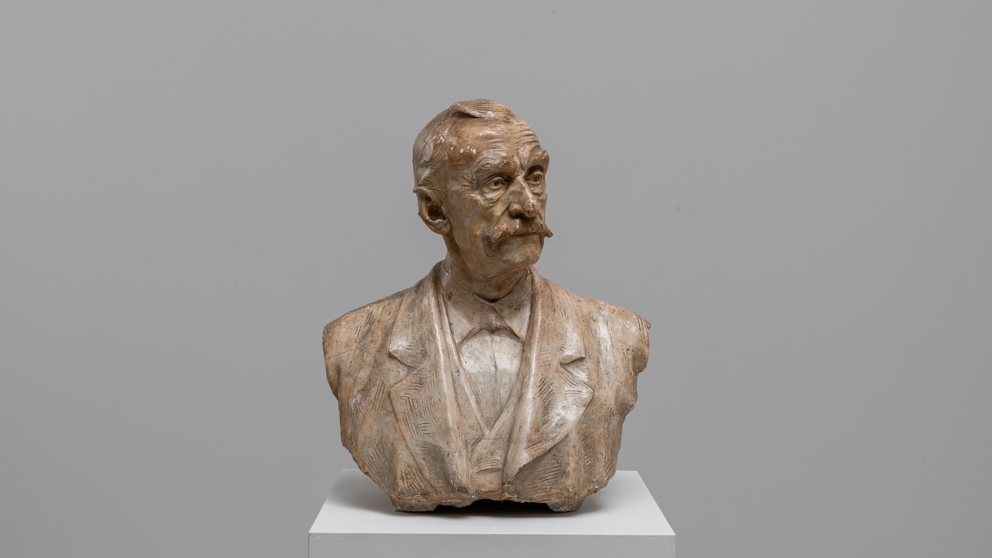 Questo busto in cemento francese del XX secolo cattura l'essenza del realismo artistico con la sua rappresentazione meticolosamente dettagliata di un anziano signore. La scultura, caratterizzata da una superficie strutturata e da un'espressione