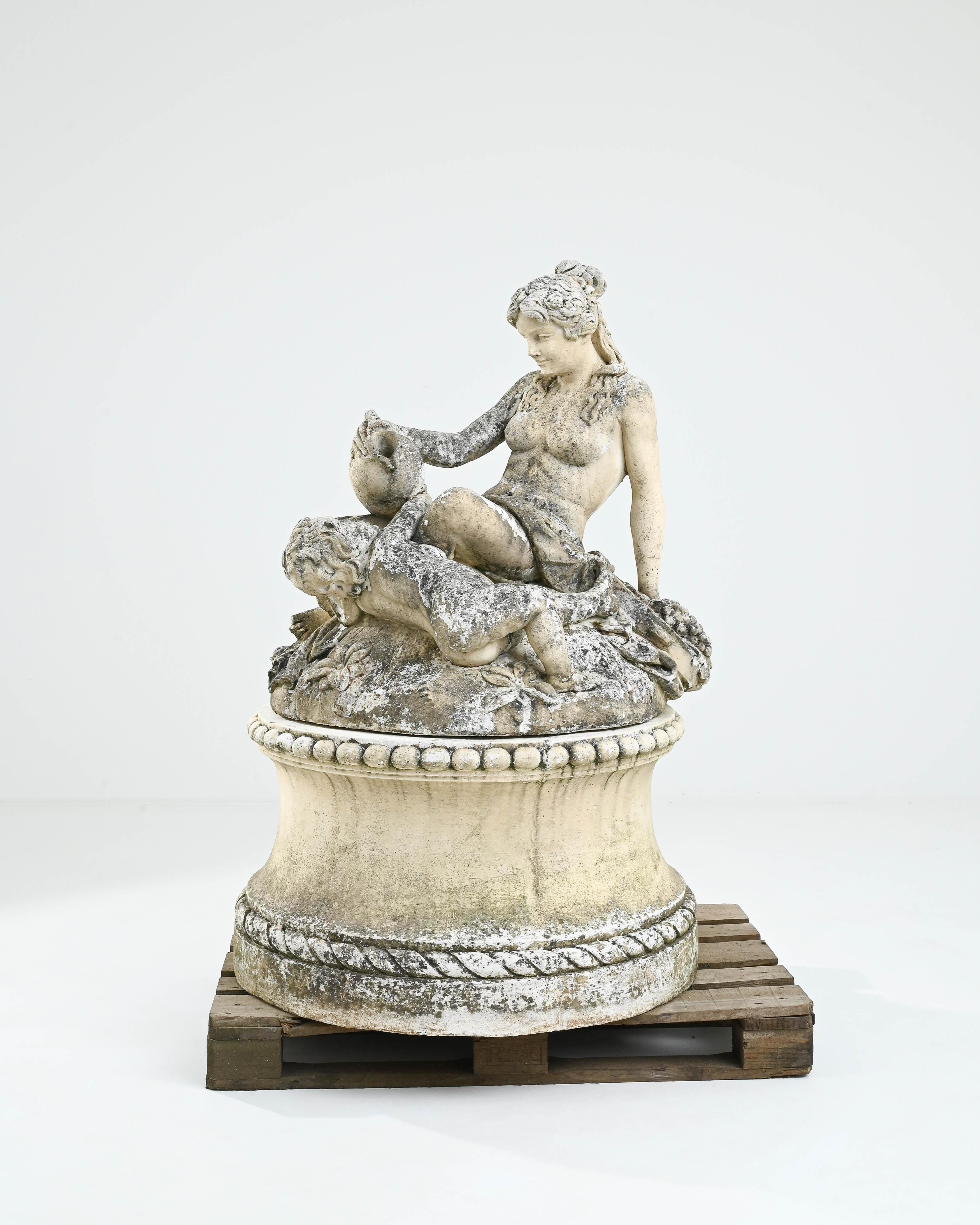 This delightful vintage garden sculpture depicting a nymph and a cherub has a Rococo levity despite its impressive stature. Made in France in the 20th century, a round base elevates the figures, who are seated naked as if upon a grassy mound. With a