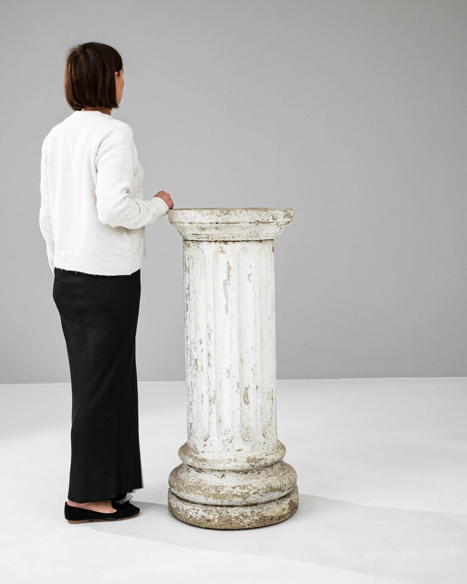 This stately 20th-century French concrete pedestal exudes a timeless elegance and a sense of architectural heritage. With its classical fluted design and robust, round base, it evokes the grandeur of ancient columns while displaying the character of