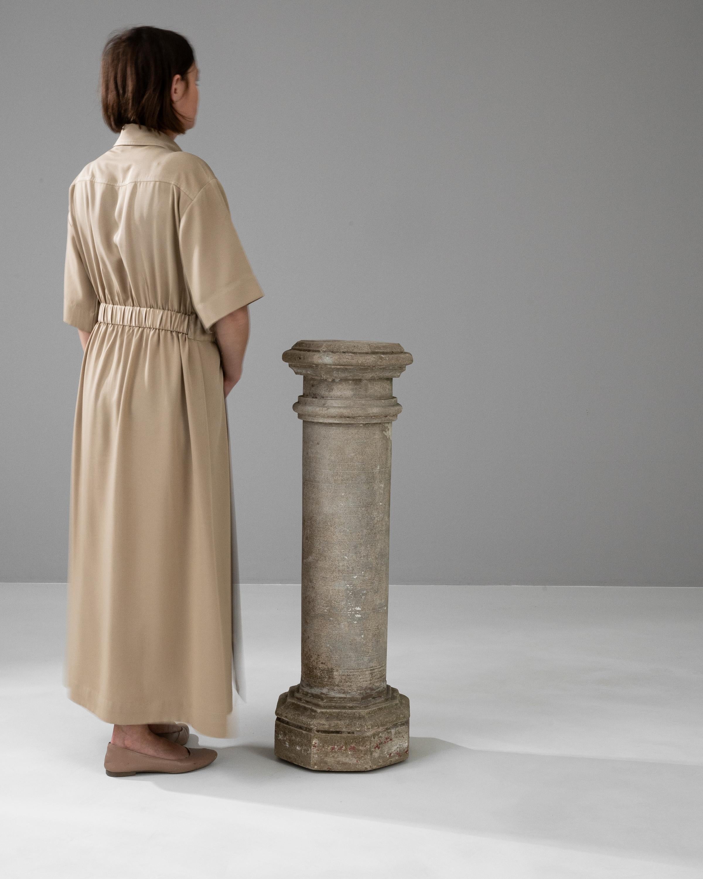 This robust 20th Century French Concrete Pedestal captures the enduring legacy of classical architecture. Its sturdy cylindrical shaft rises from a solid, square base, leading up to a dignified capital, which showcases subtle detailing reminiscent