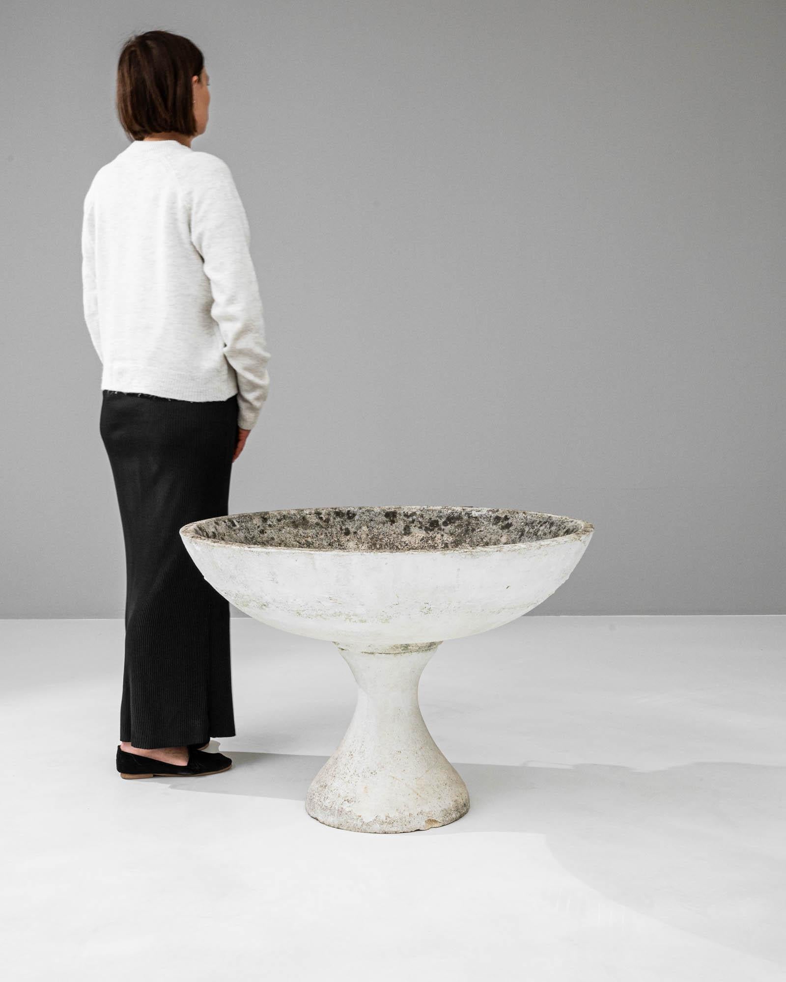 This 20th-century French concrete planter offers a sleek, minimalist silhouette that blends the roughness of its material with a design that exudes modern elegance. The chalice-like shape draws inspiration from classical forms, while the raw,