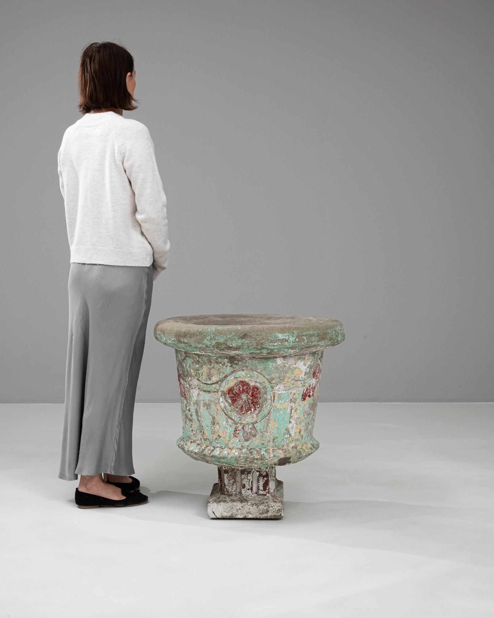 Elevate your garden with this exquisite 20th Century French Concrete Planter, a masterpiece of vintage charm and character. This planter stands out with its richly textured surface, showcasing layers of peeling paint in shades of sea green and