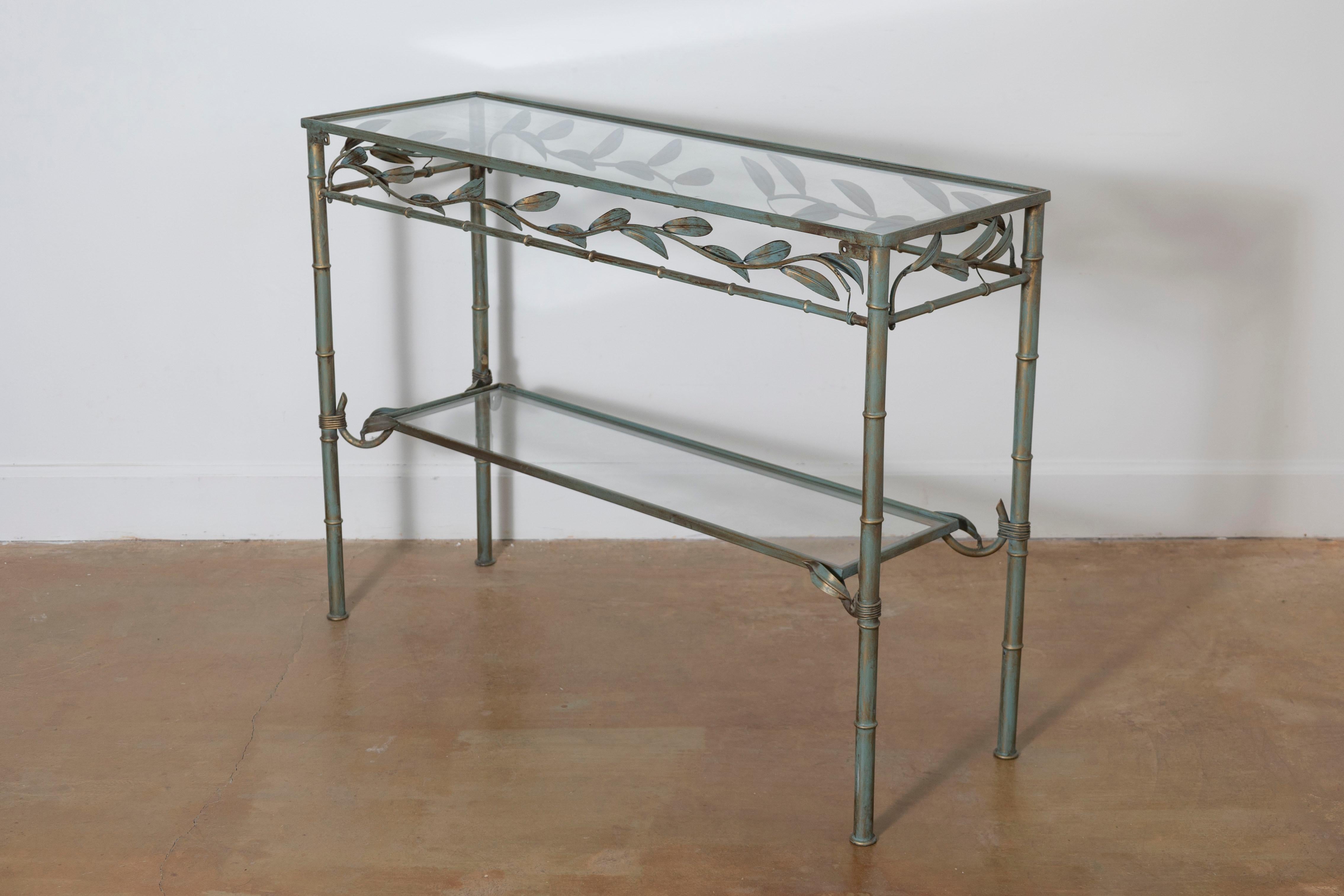 This 20th-century French console table embodies a light and airy aesthetic, blending functionality with artistic craftsmanship. Constructed from wrought iron with a patinated finish, the table features a bamboo-inspired design on its legs and frame,
