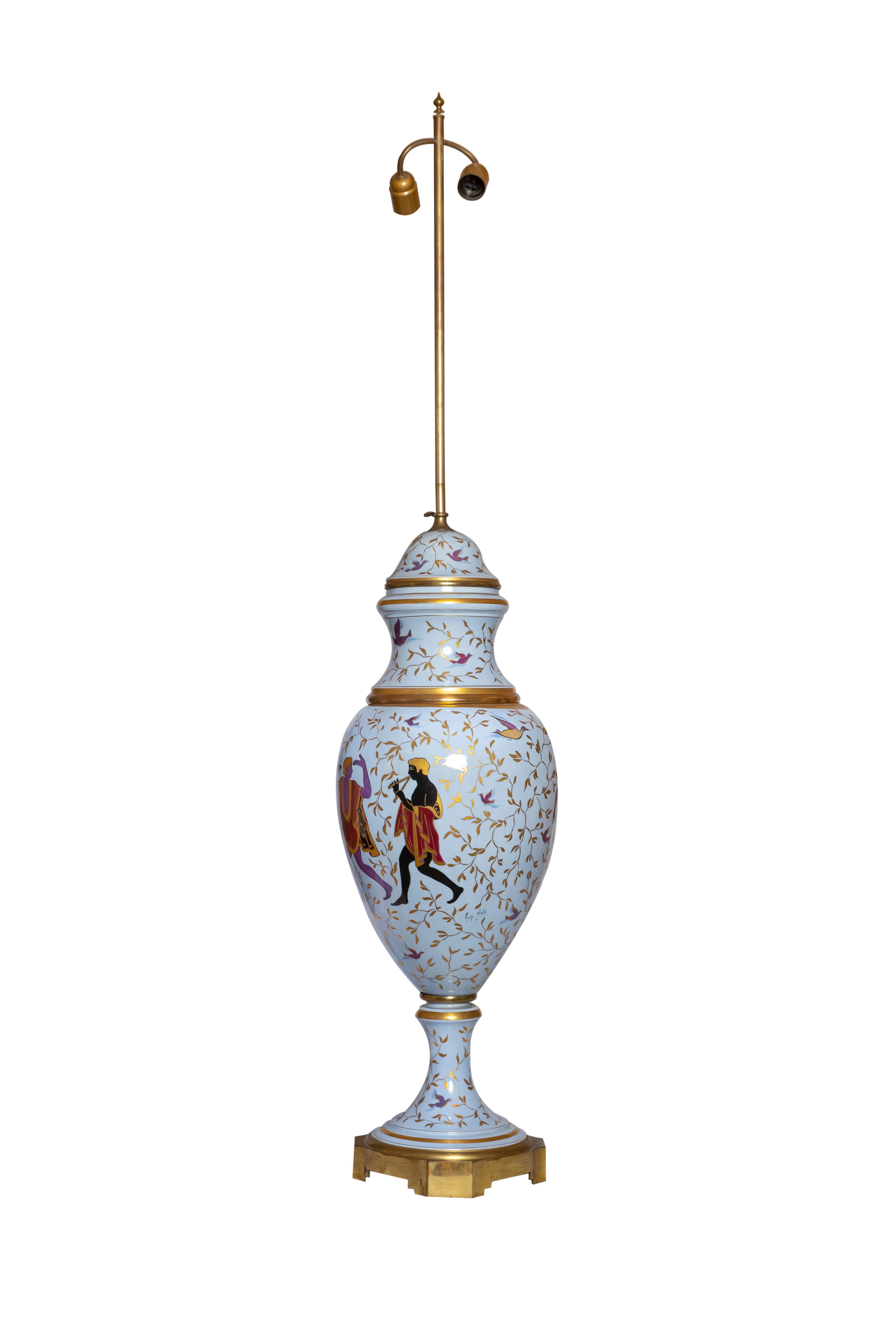 A 20th century french Porcelaine de Sèvres, Hauts-de-Seine, painted vase mounted as a table lamp with gilted details and brass base.
Gilt foliate and purple bird decoration, The body is decorated with dancing figures after the antique on a blue