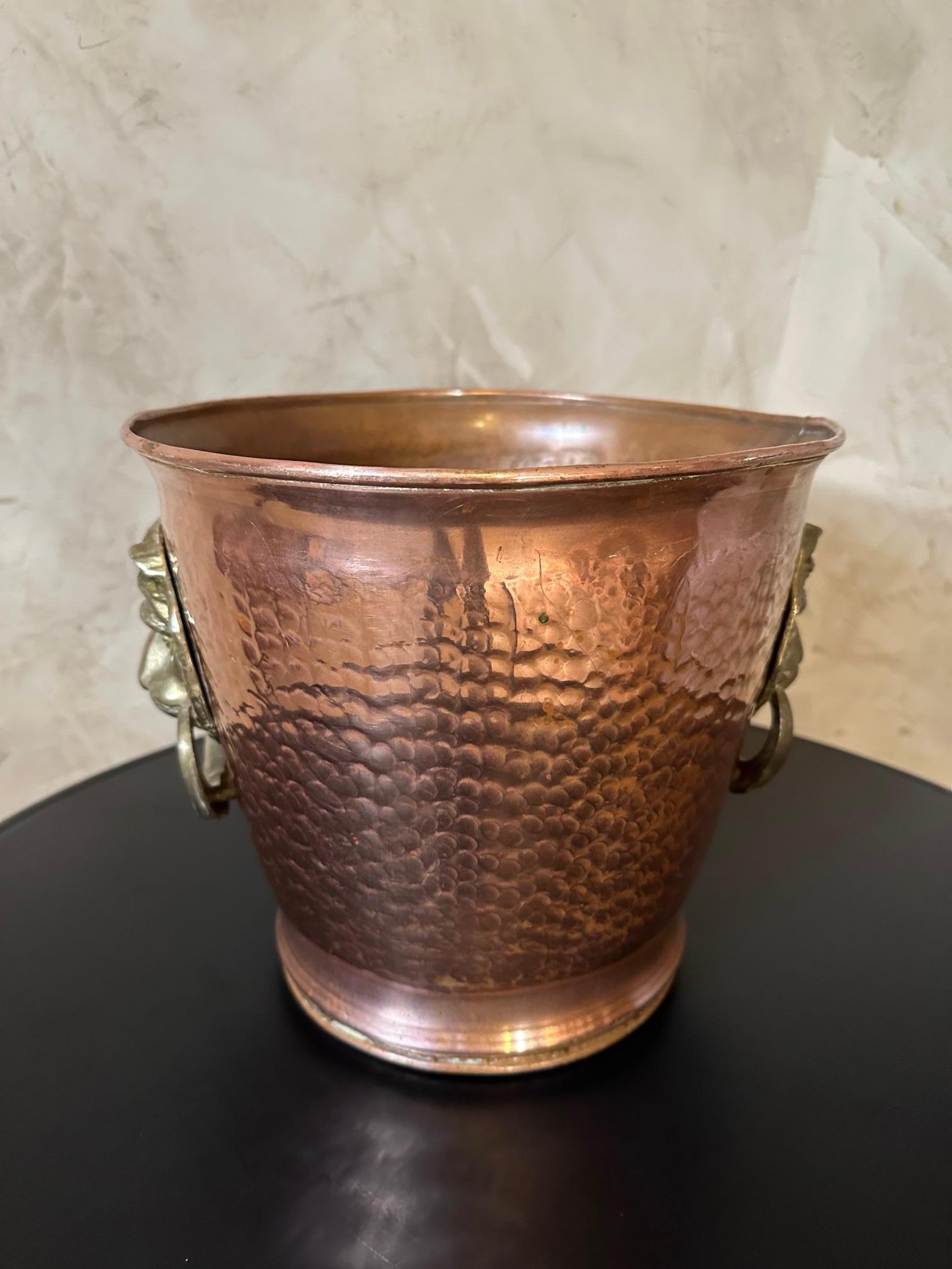 Copper champagne bucket from the 1950s with two brass lion heads as handles. The copper is hammered. Original model. For lovers of beautiful traditional pieces. Good condition.