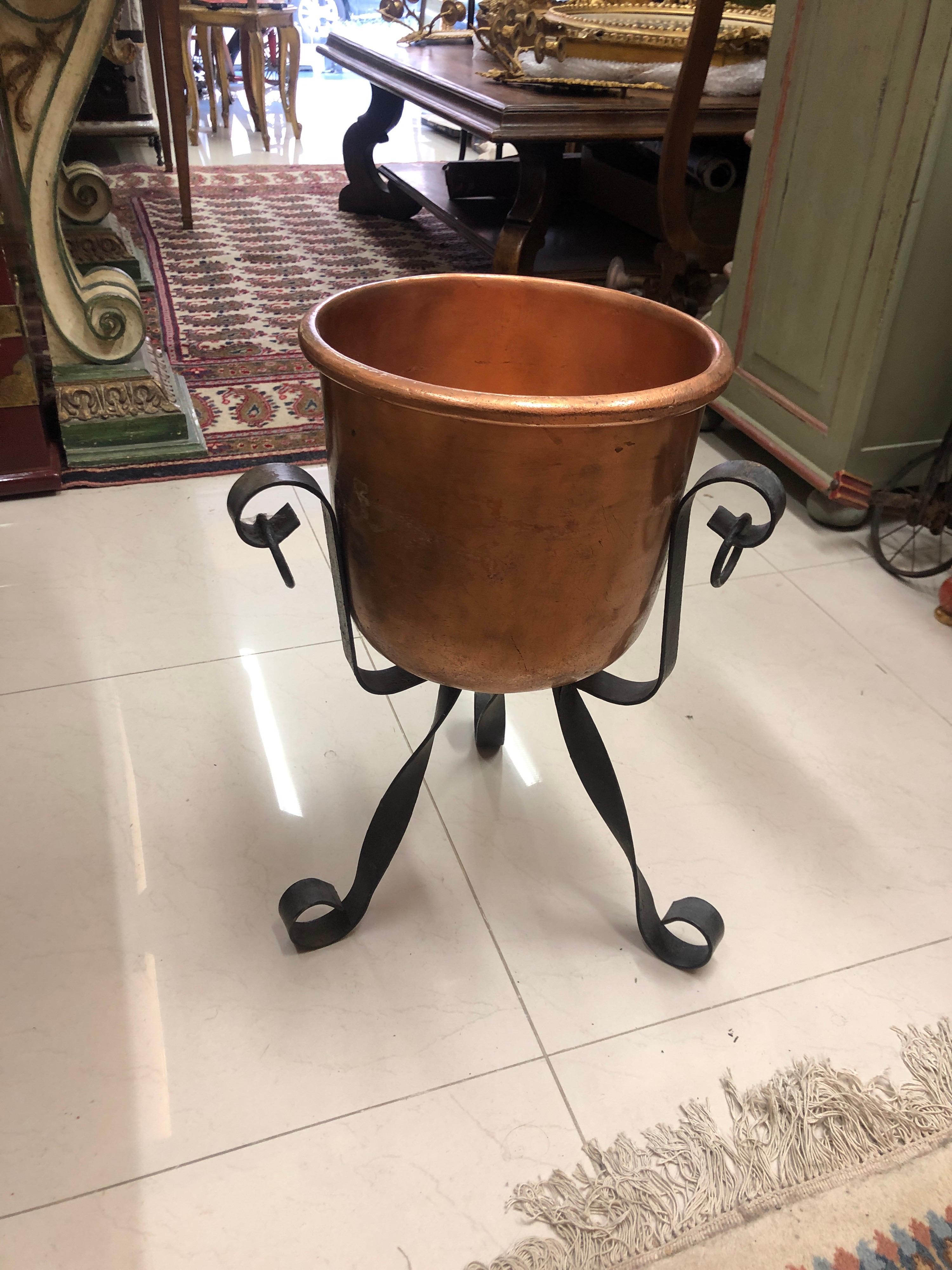 Hand made large copper bowl or ice bucket standing on a tripod base of wrought iron.
France, circa 1920.