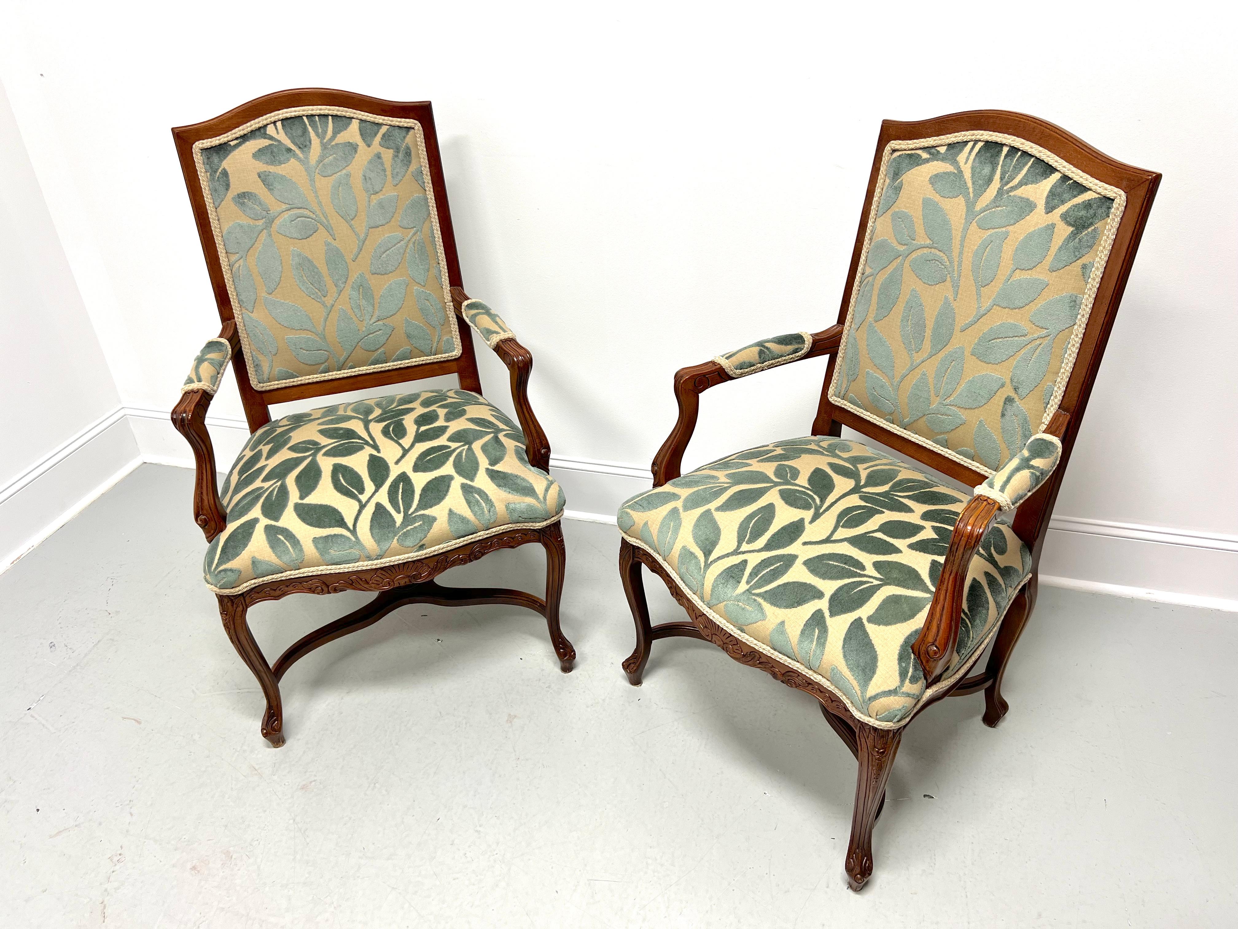 A pair of French Country Louis XV style fauteuils open-arm armchairs, unbranded. Carved walnut frame, curved arms with carved supports, brocade fabric upholstery of teal (green-blue) & silver, carved apron, curved legs, 