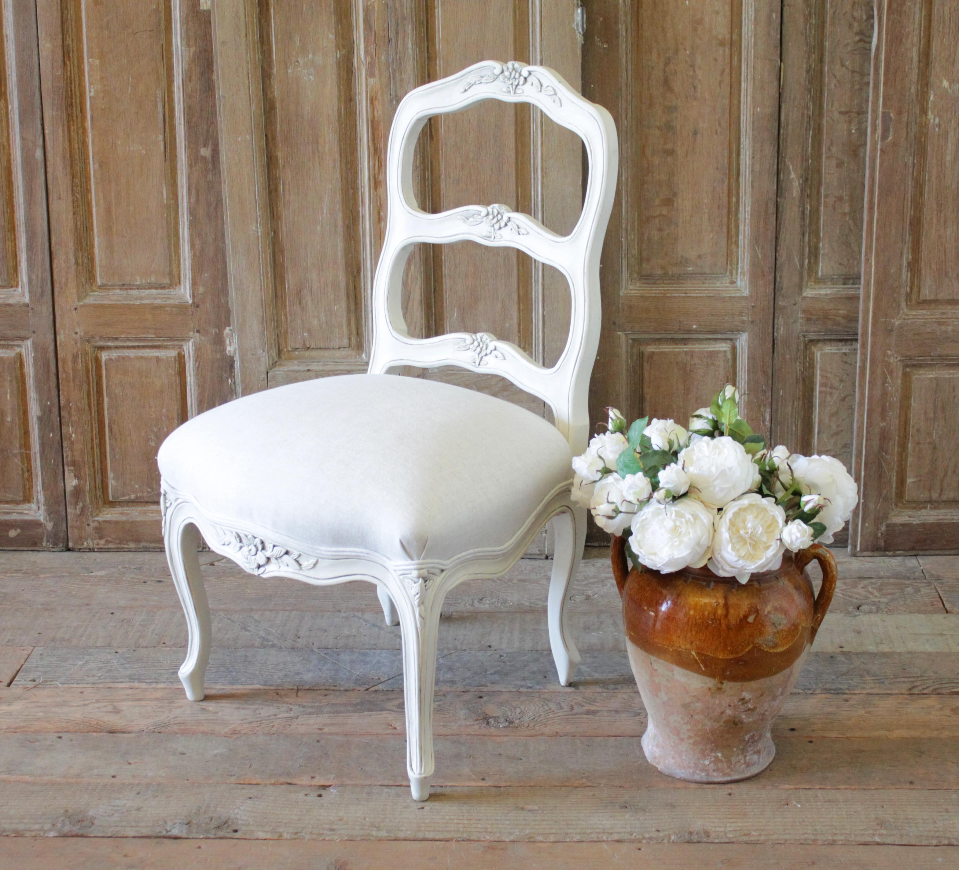 20th century French Country style ladder back accent chair.
Beautiful painted chair in our oyster white finish, with subtle distressed edges, and finished with an antique glazed patina. Great for a vanity chair or desk chair. Greige colored natural